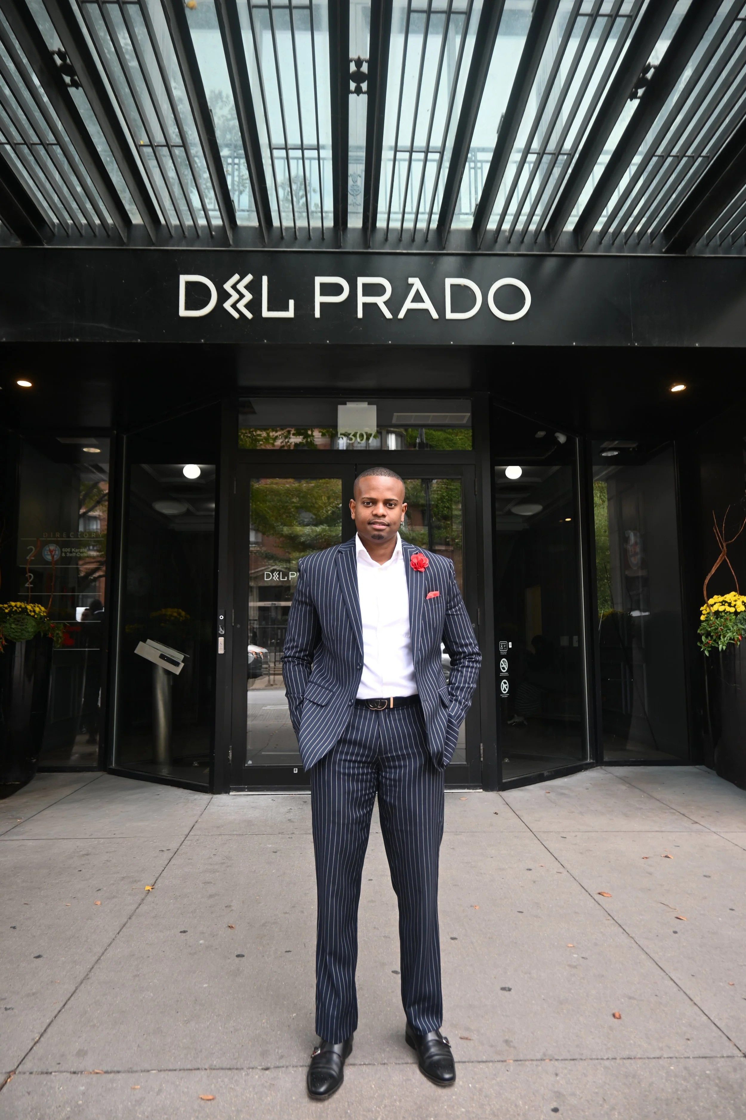 NWM Hyde Park's Dundee Gouin Standing in Front of Del Prado Building.