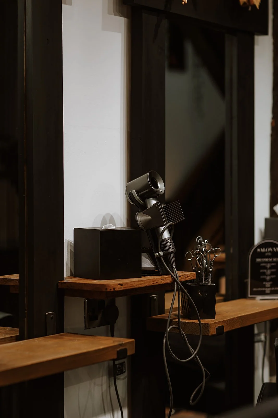 Hairdryers and scissors on shelves in Salon XV in Oswestry.