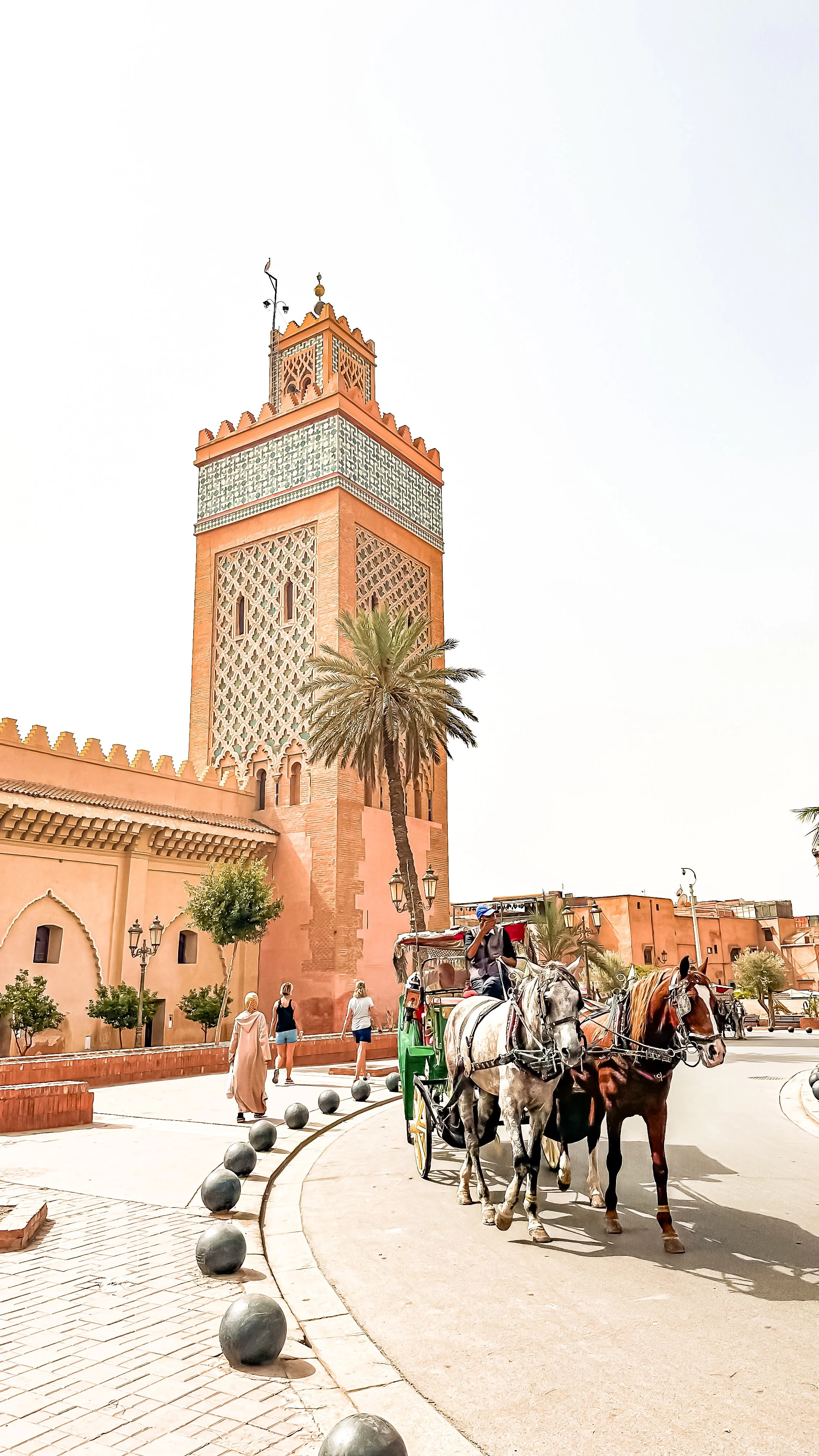 Koutoub mosquee of Marrakech exterior with horses passing by