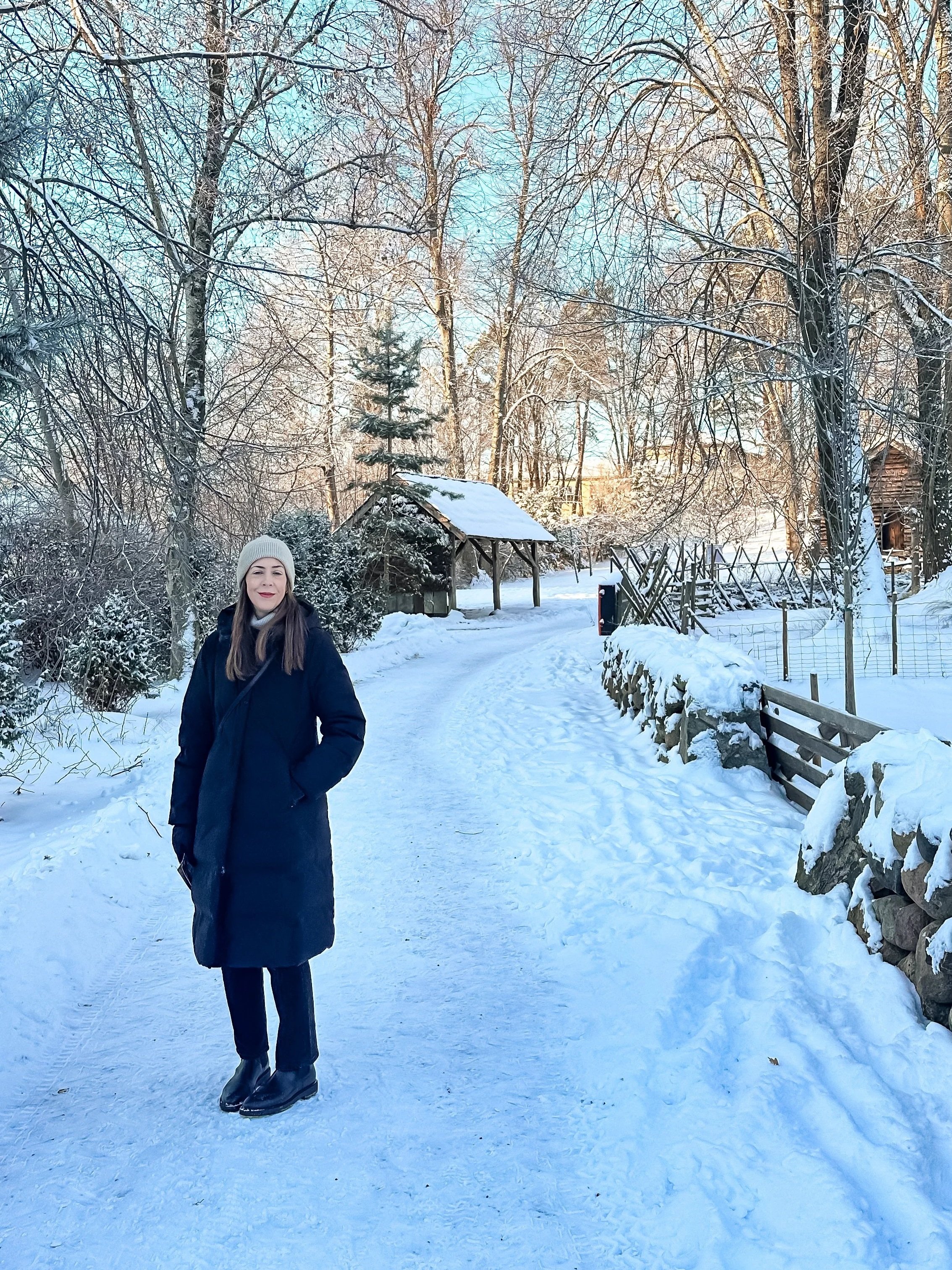 wander-senses-norway-oslo-guide-folk-museum-wooden-houses-covered-with-snow-woman-walking-trough-path.jpg