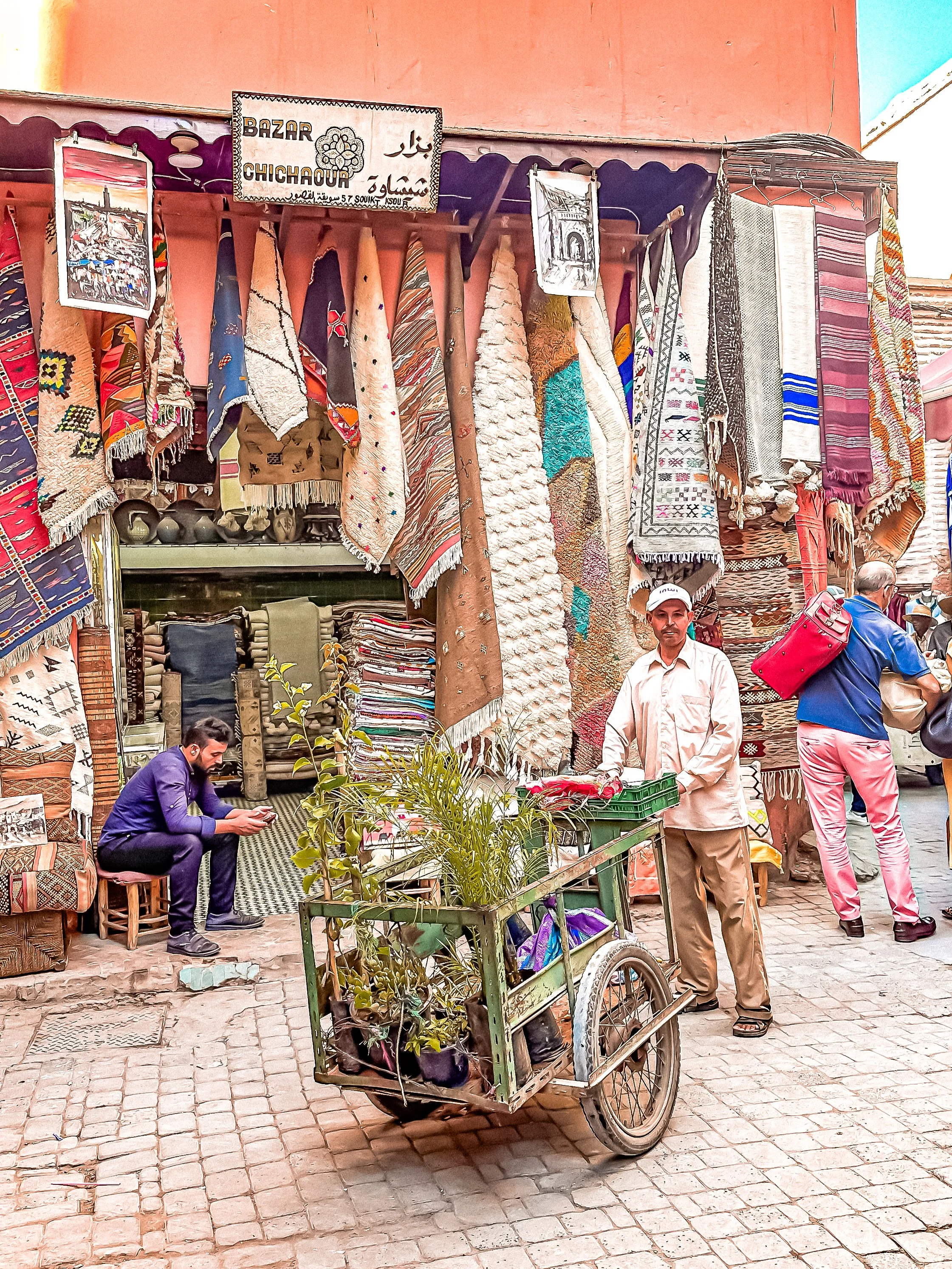 wander-senses-marrakech-souk-carpets-and-men-holding-charriot.png