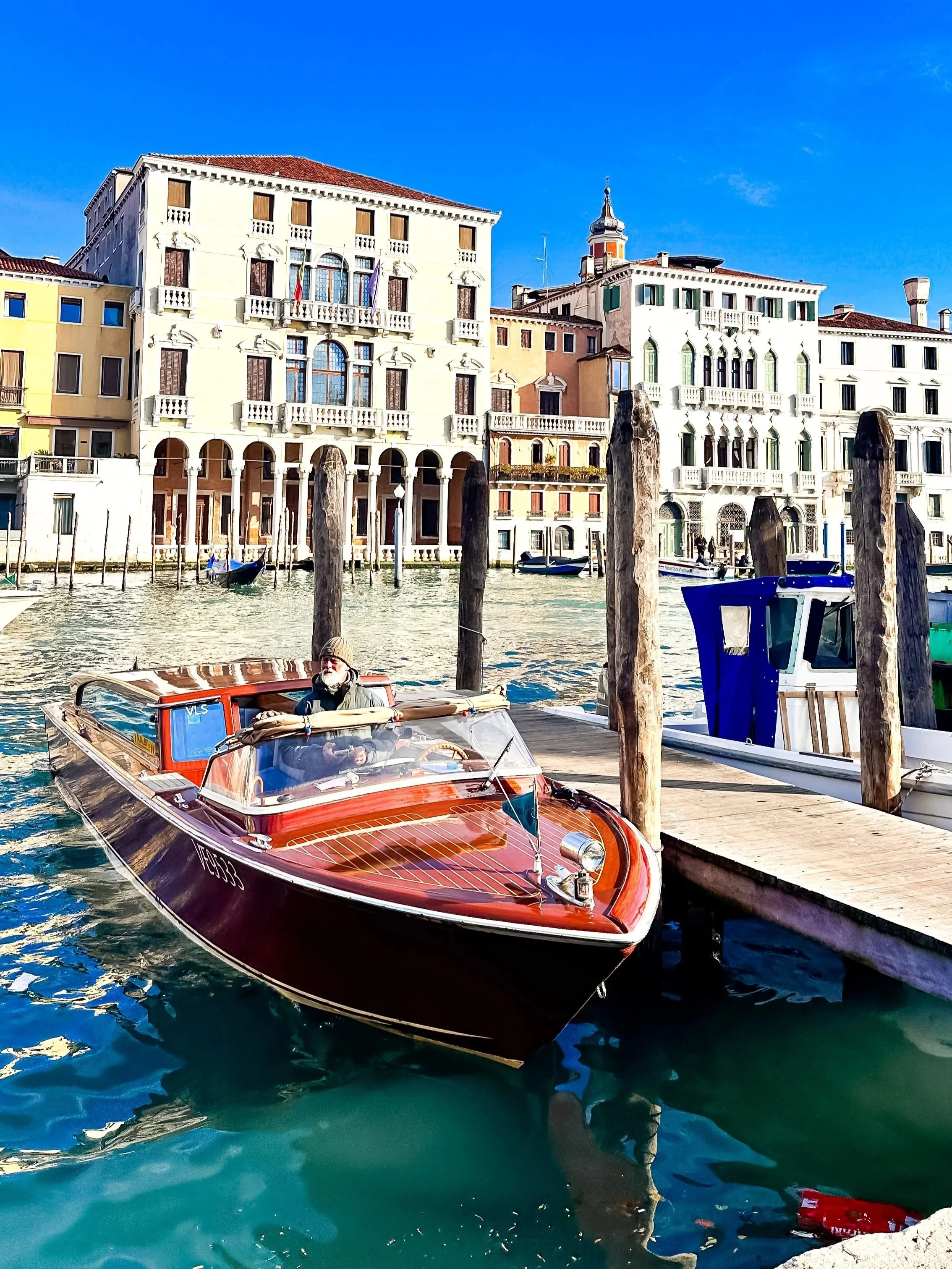wander-senses-venice-wooden-boat-parked-on-canal.jpg