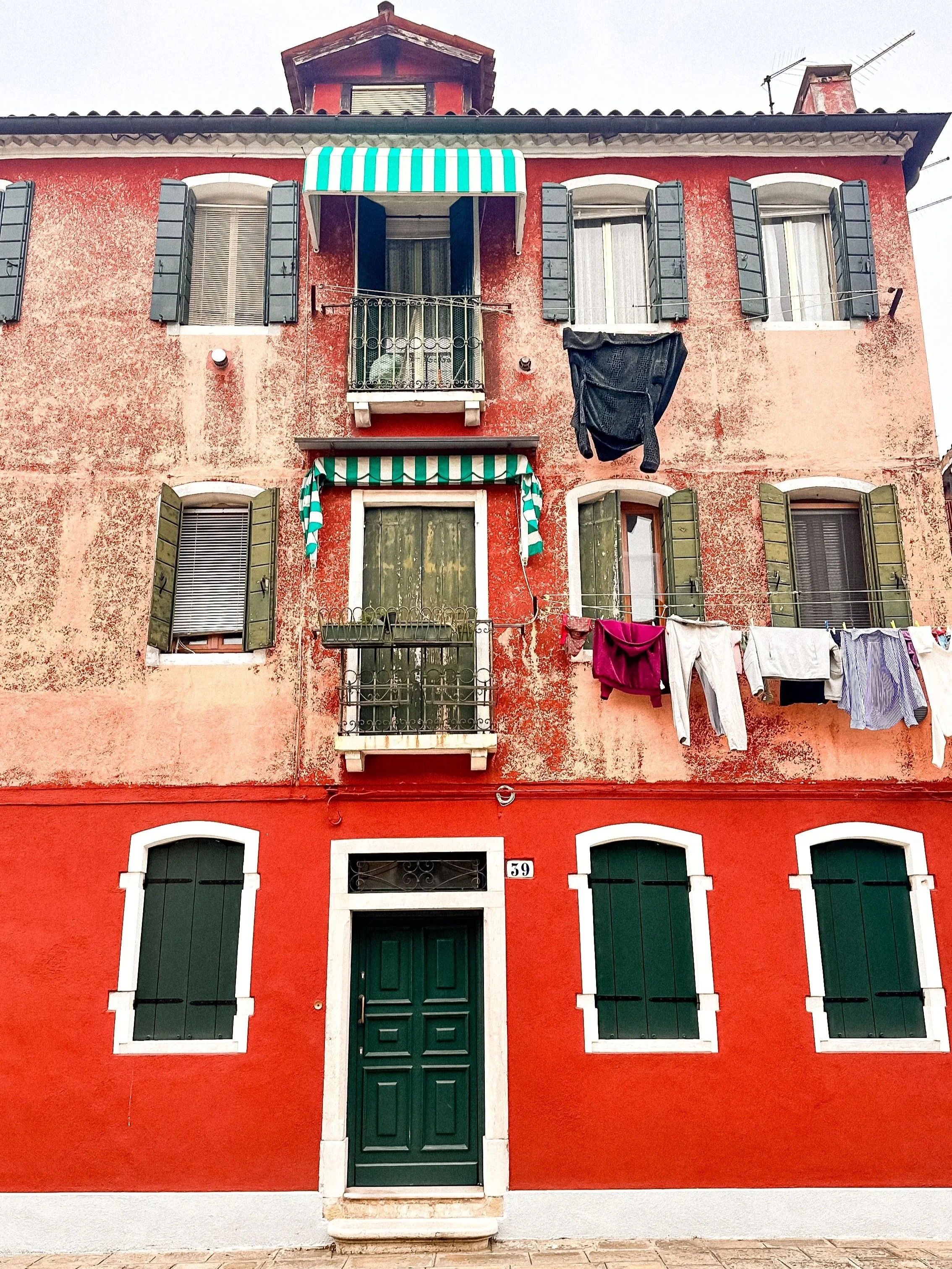 wander-senses-murano-red-building-with-clothes-hanging-to-dry.jpg