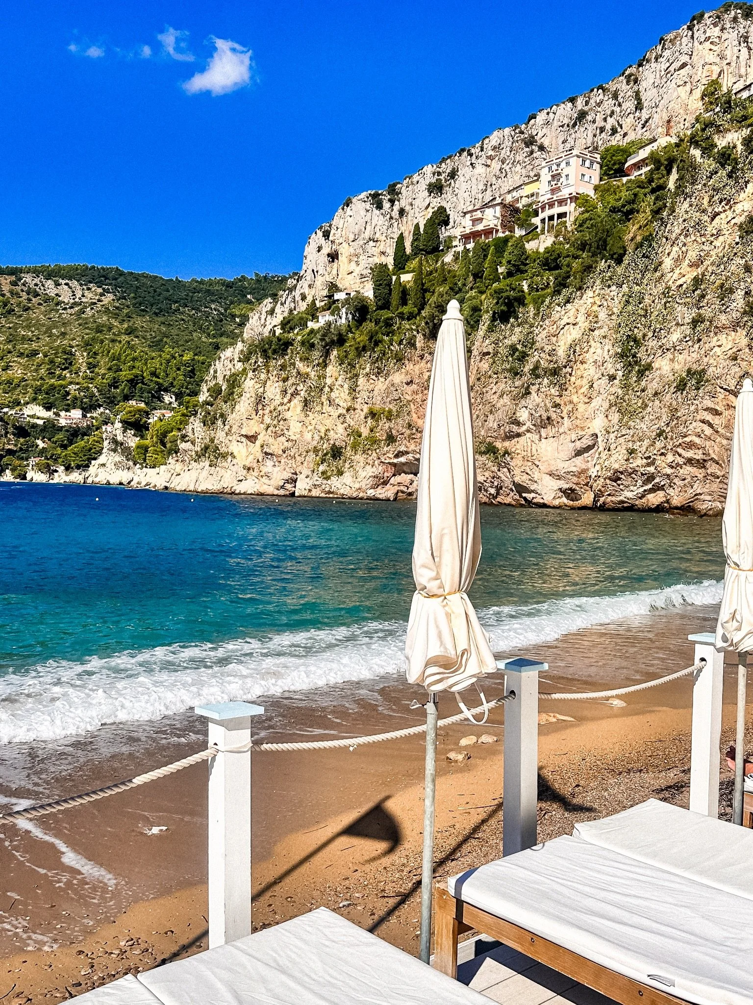 Plage de la Mala is one of my favorite spots on the Frenc Riviera. Just below the cliffs in Cap d&rsquo;Ail, it feels a bit more tucked away than the other beaches nearby. You have to walk down to get there, but that&rsquo;s part of what makes it spe