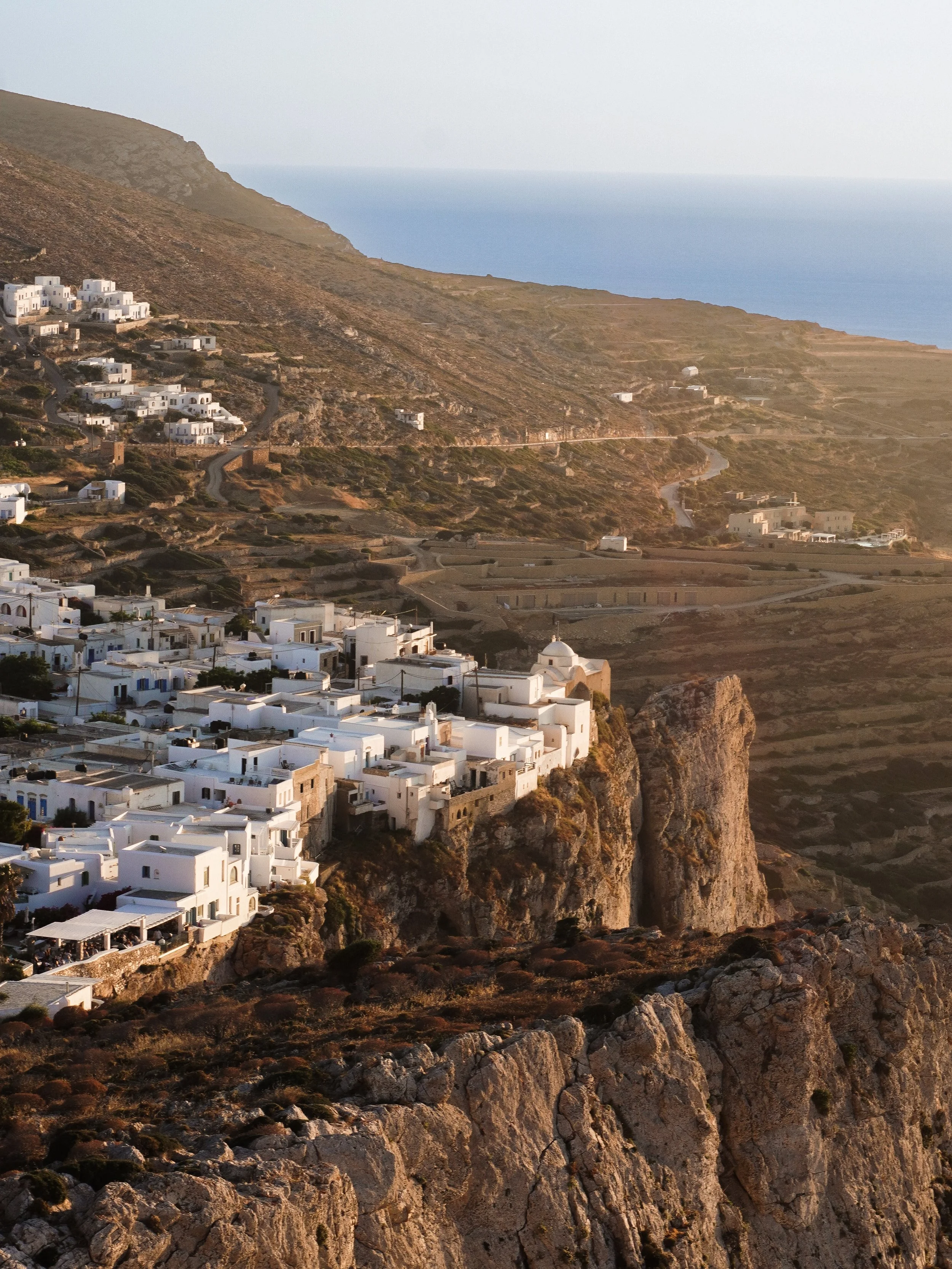 Every island has that one place you end up talking about long after the trip. For me, in Folegandros, it was the walk up to the Church of Panagia.

Just before sunset, everyone heads up the hill, and you sit on the stone walls, watch the light slowly