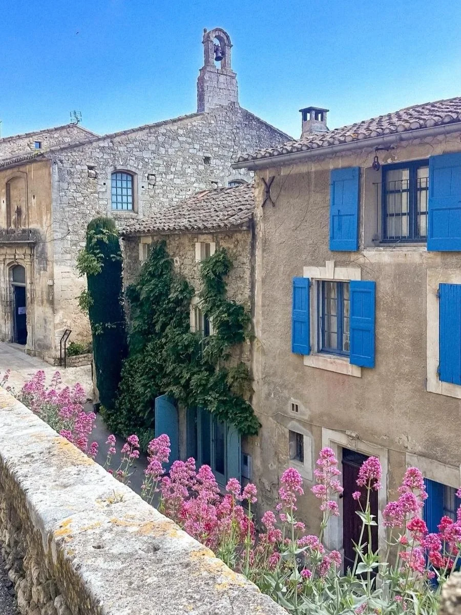 image oh a provencal house with blue windows and pink flowers in Menerbes France