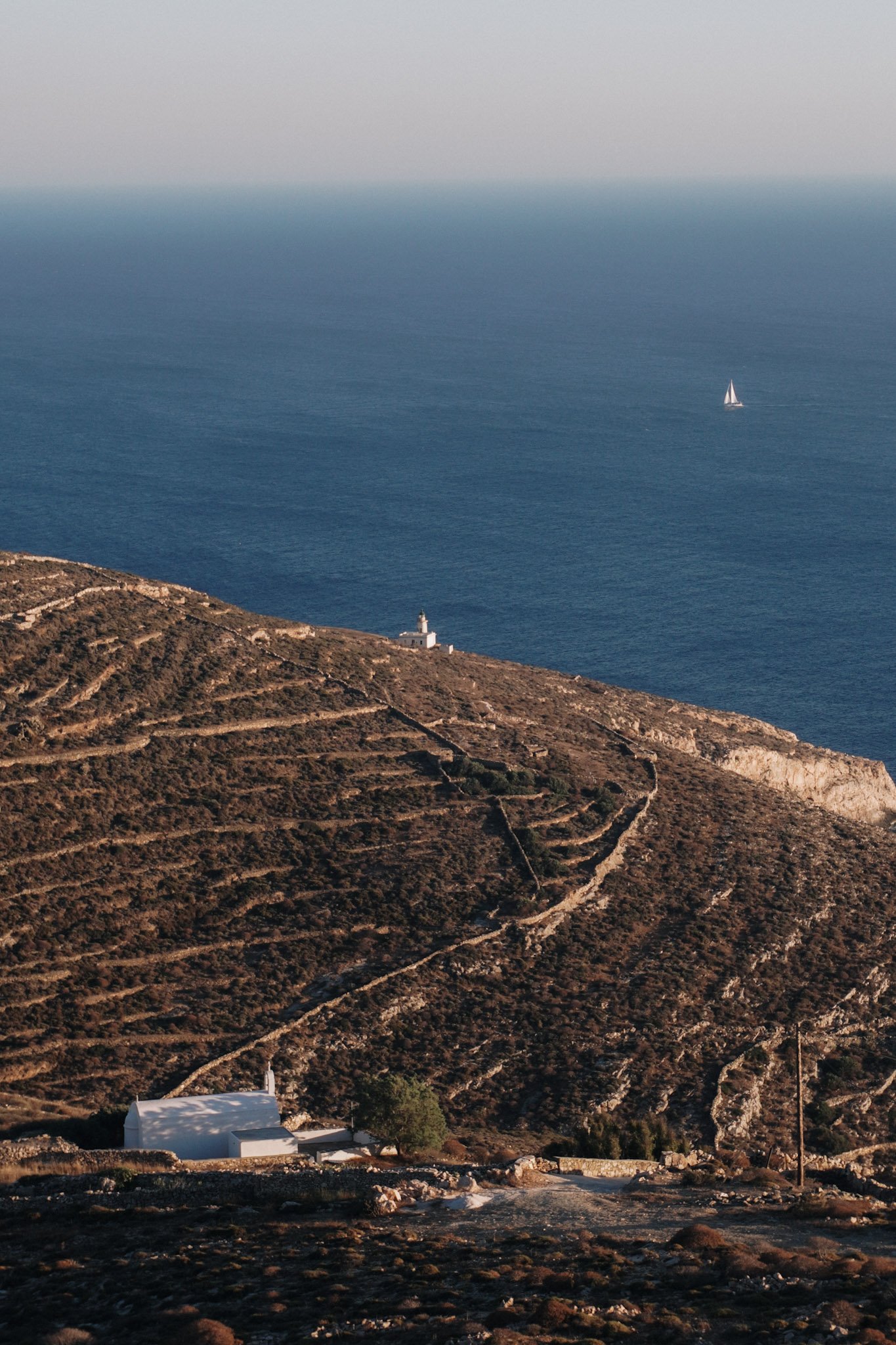 top view to the mountains and sea with a sail boat in the horizon in Folegandros