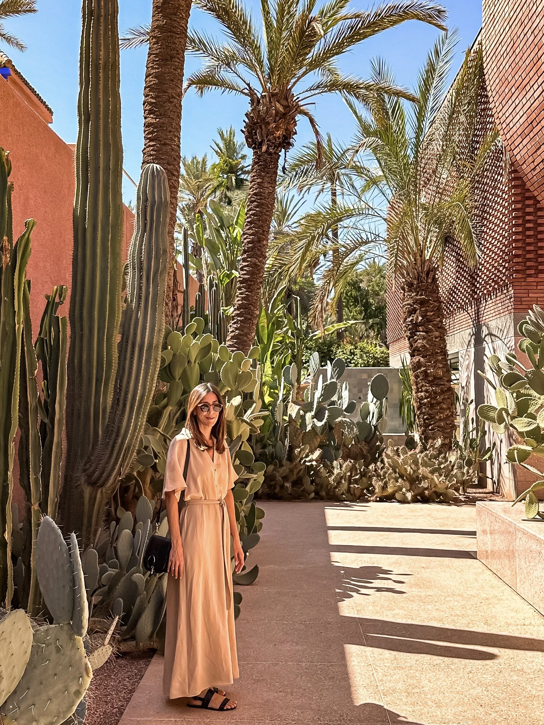 wander-senses-marrakech-yves-saint-laurent-museum-exteriors-terracota-building-woman-wearing-beige-long-dress.JPEG