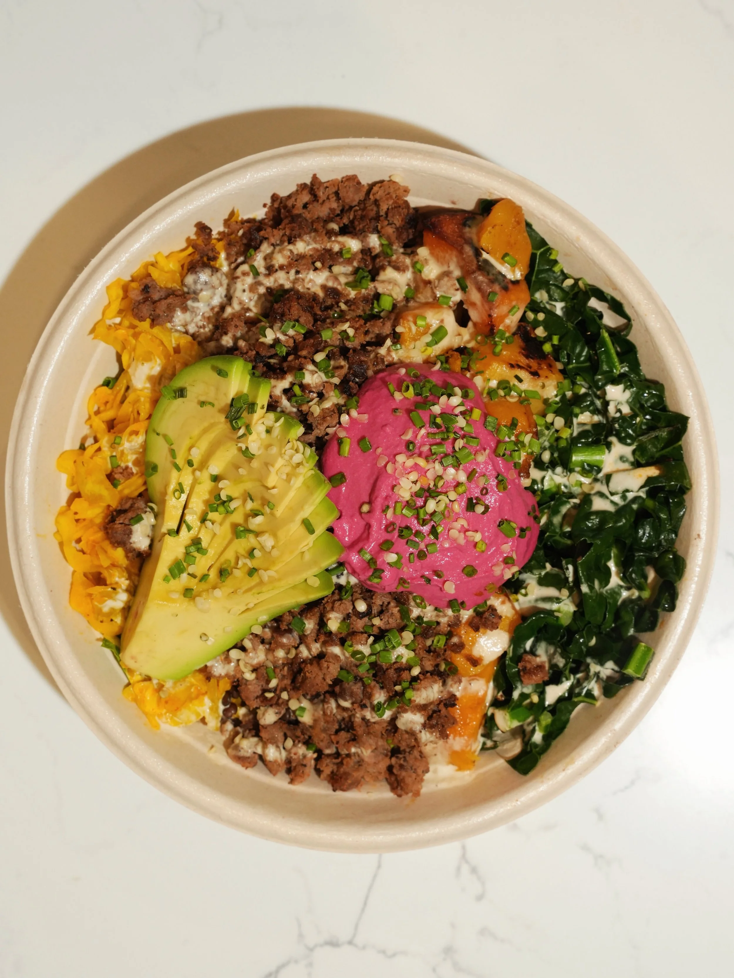 One of our best sellers for a reason.

The Macro Bowl is packed with plant-based protein and nutrient-dense ingredients including roasted butternut squash, steamed kale, sliced avocado, black lentils, beet hummus, golden kraut, tahini drizzle, hemp s
