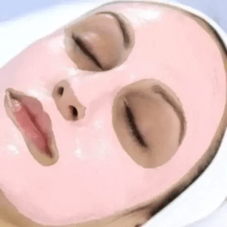 A person is lying with a pink facial mask applied, with eyes closed and lips slightly parted.