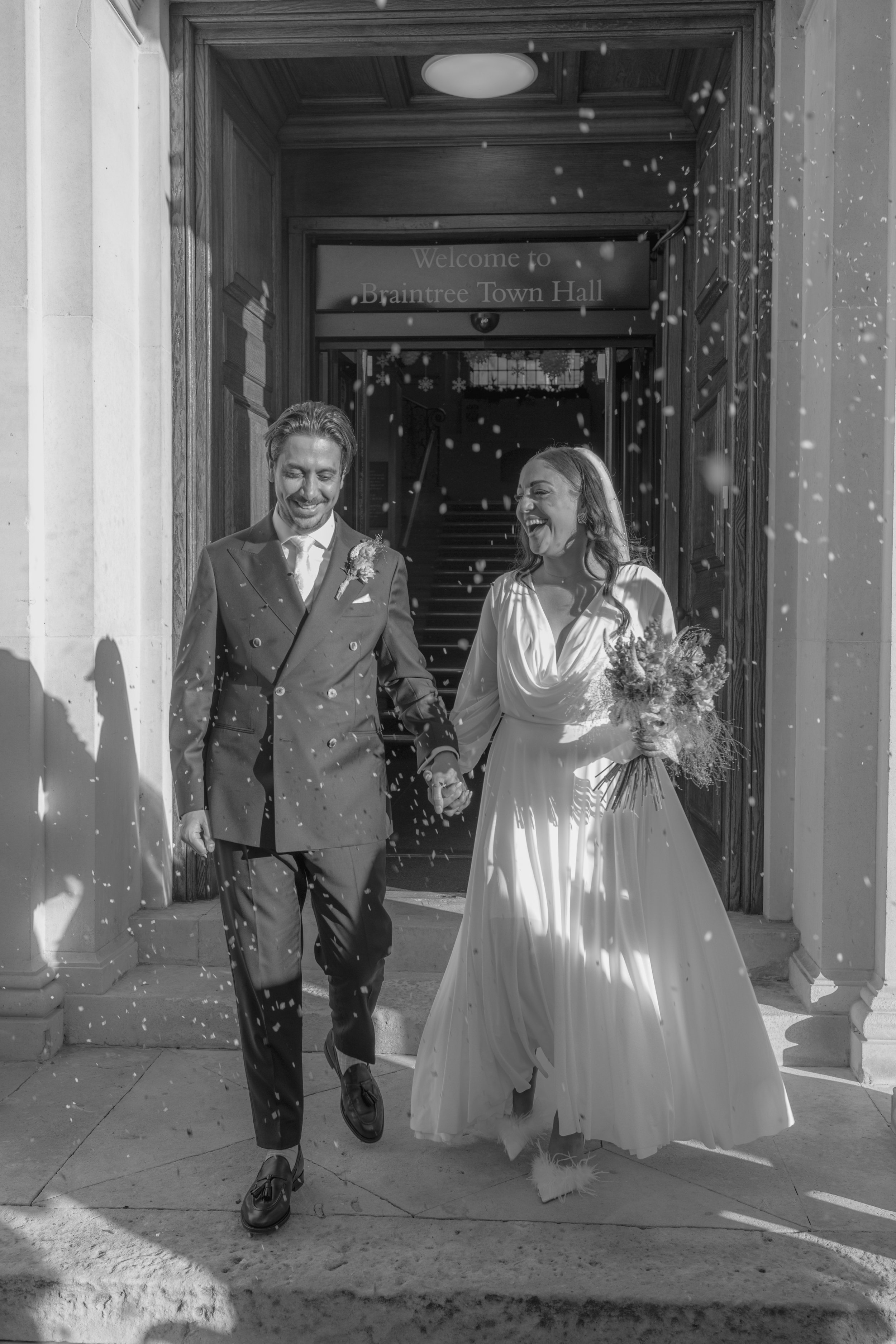 bride and groom walking with confetti in the air