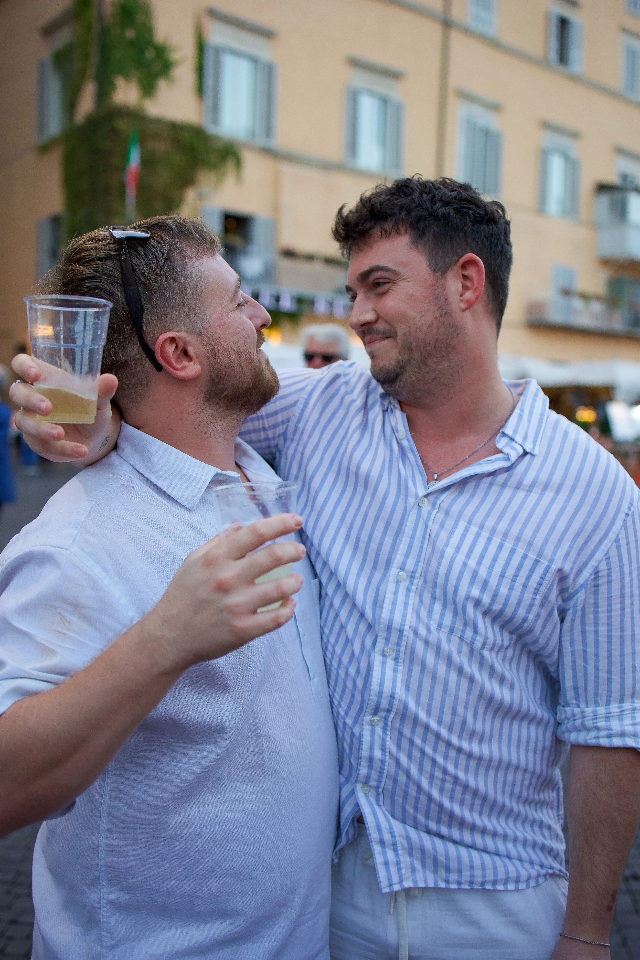 gay couple embracing, looking at each other and smiling