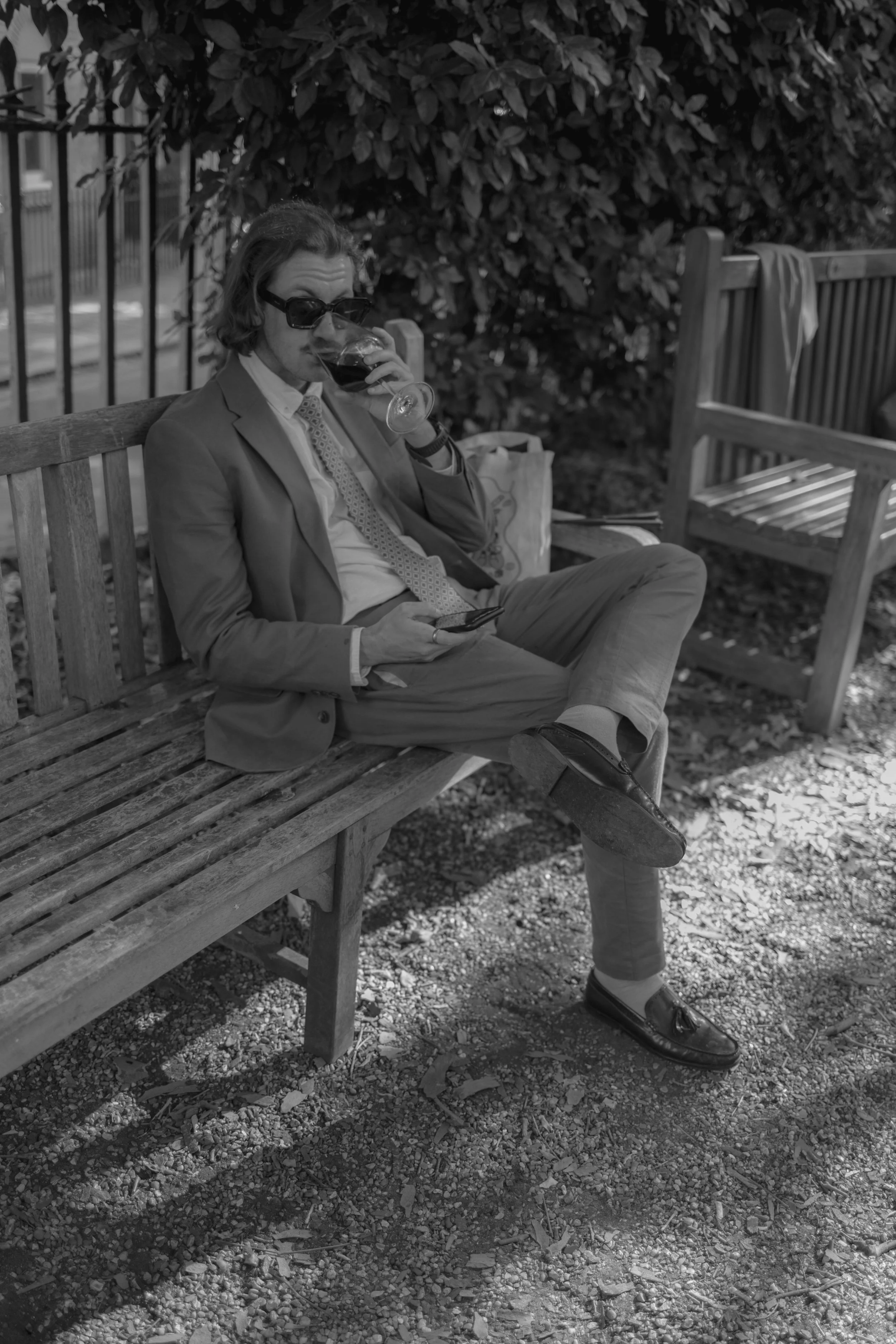 wedding guest in sunglasses taking a sip of his cocktail