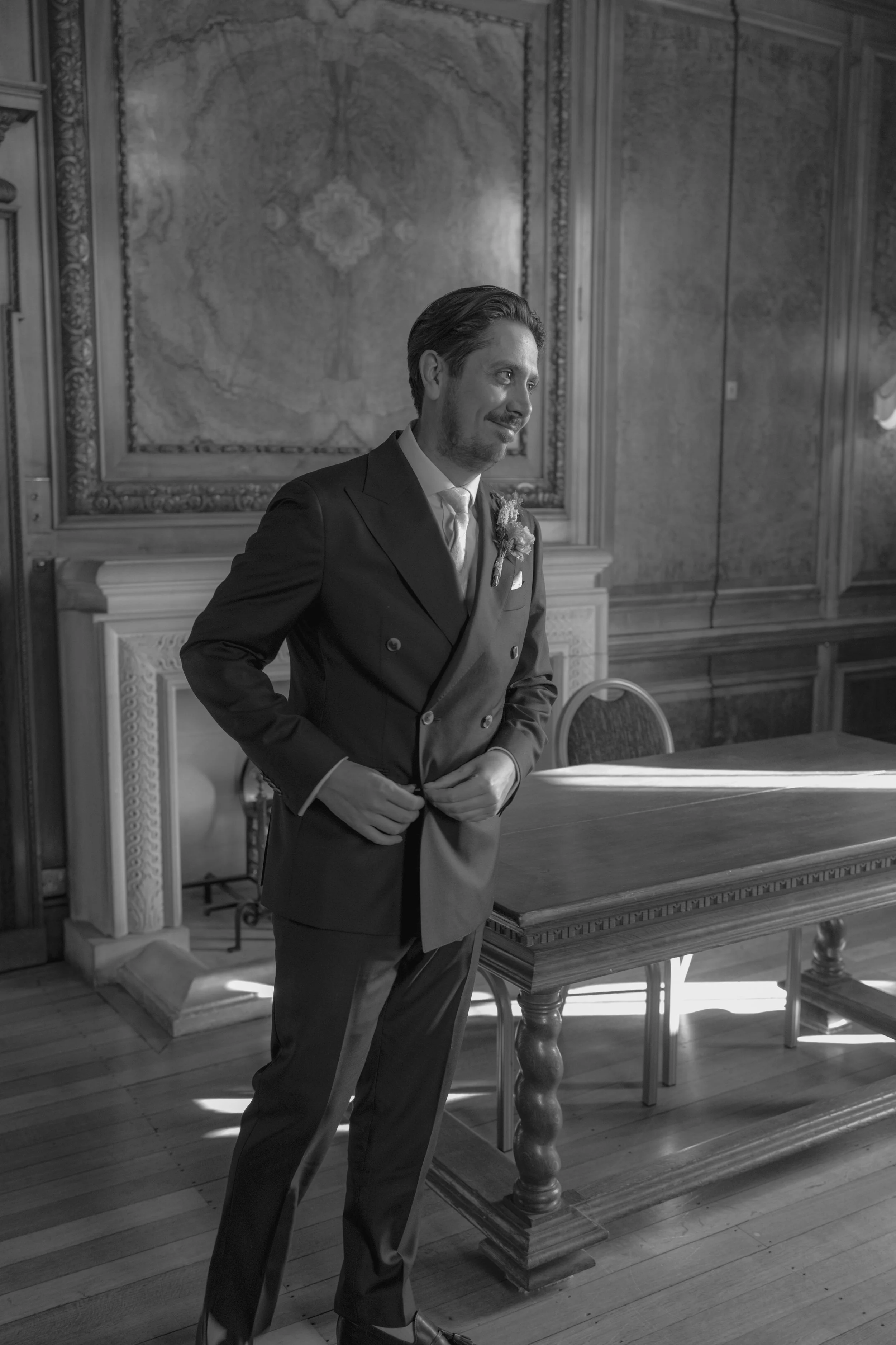 groom doing up the button on his jacket