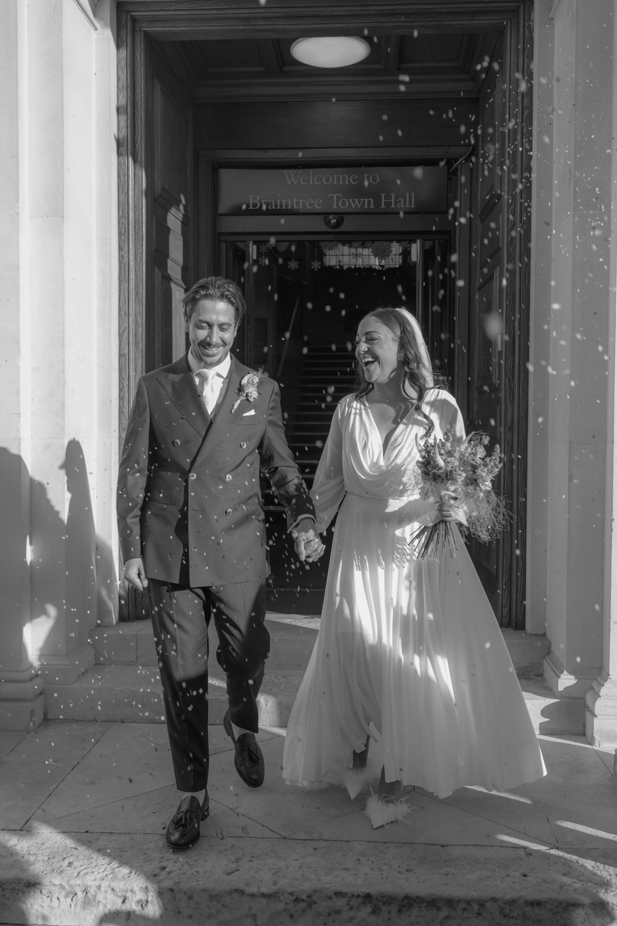 happy bride and groom exiting a townhall to confetti 