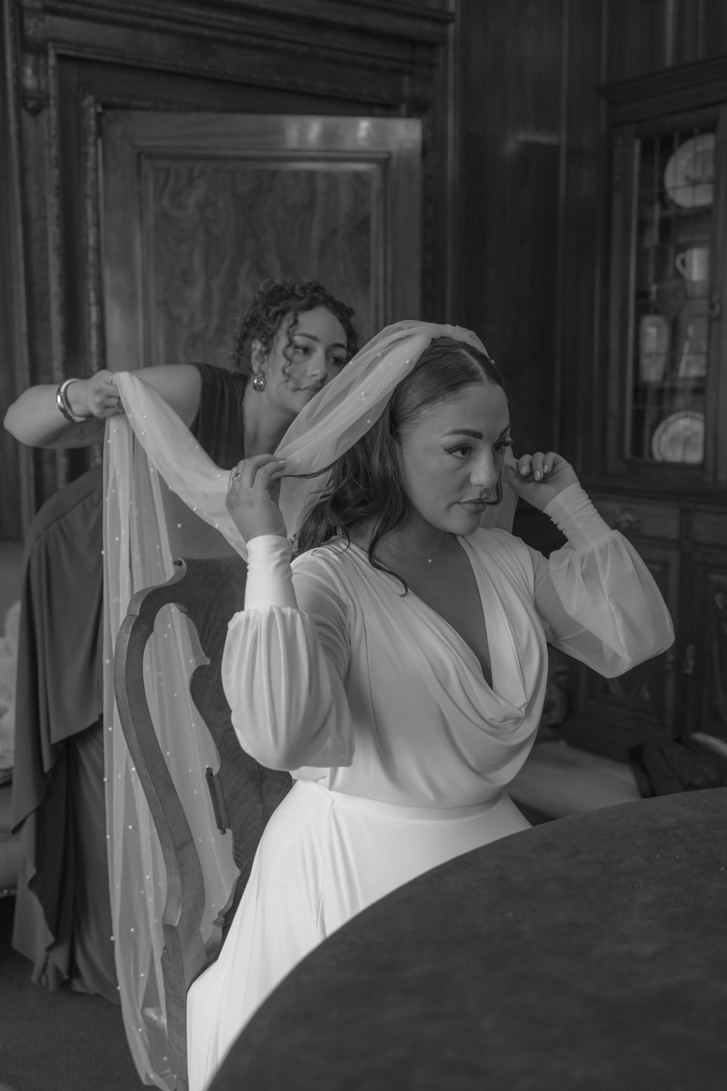 lady helping a bride put on her veil