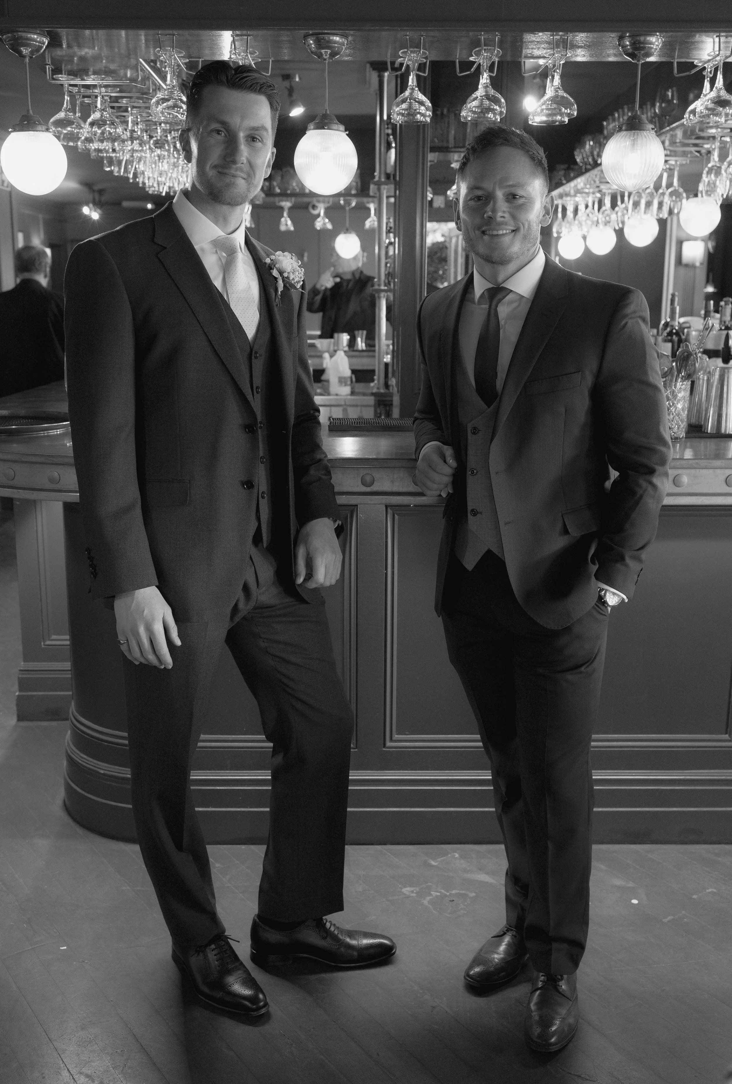 groom and groomsman stood at a bar