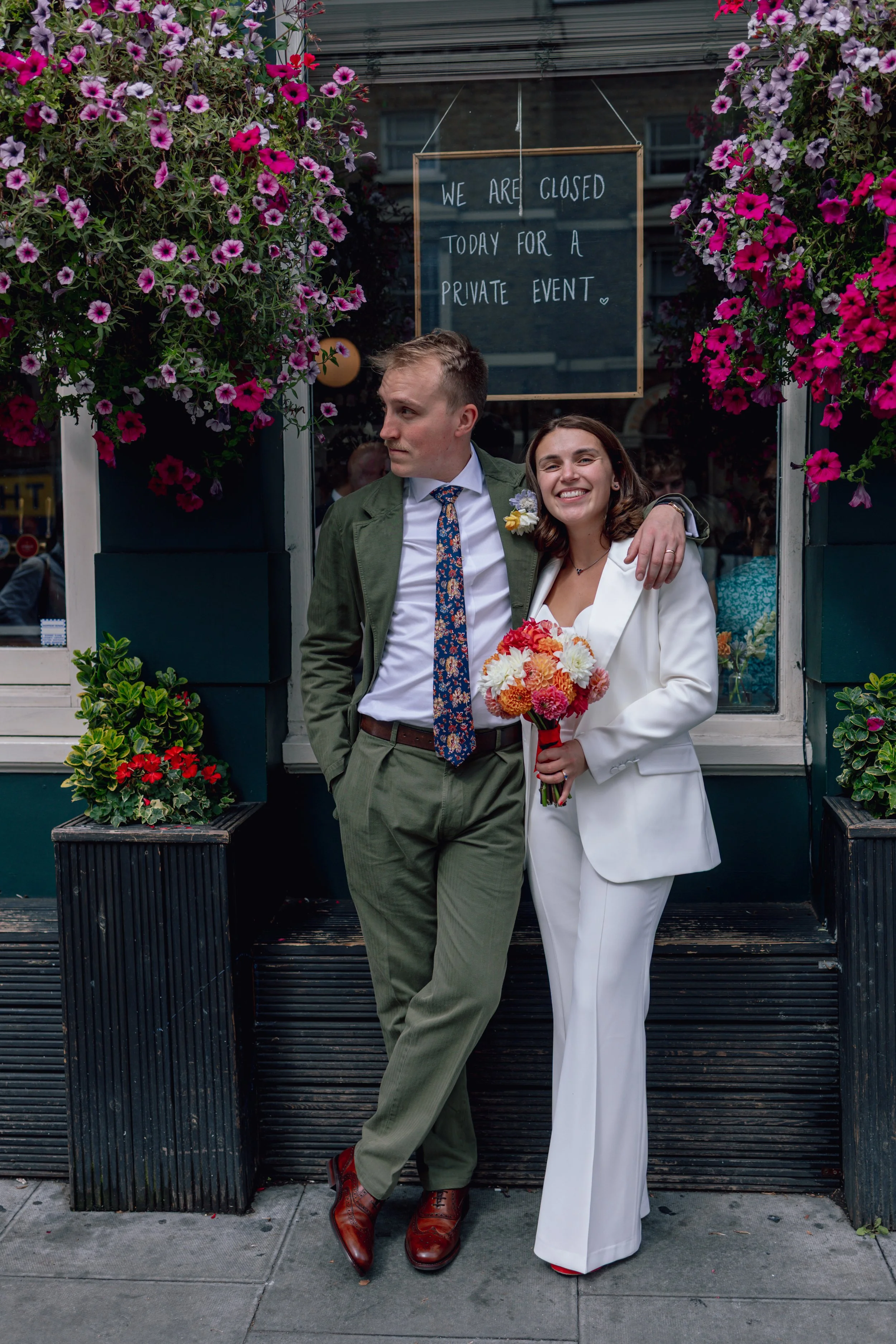 bride and groom stood outside a colourful London pub