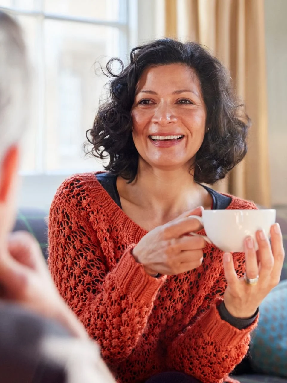Woman drinking tea at home, representing midlife transitions therapy in Newport, Oregon