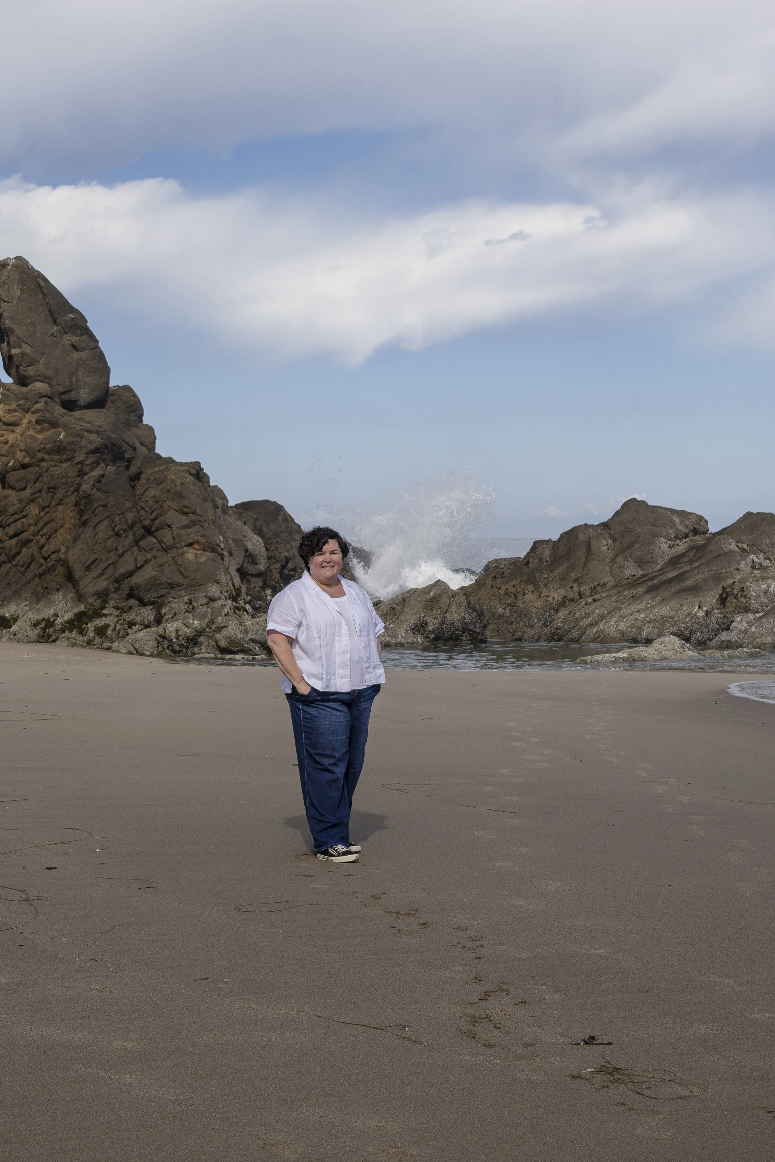 Heather Pierce standing on the rocky Oregon Coast near Newport, weight-inclusive therapist office setting