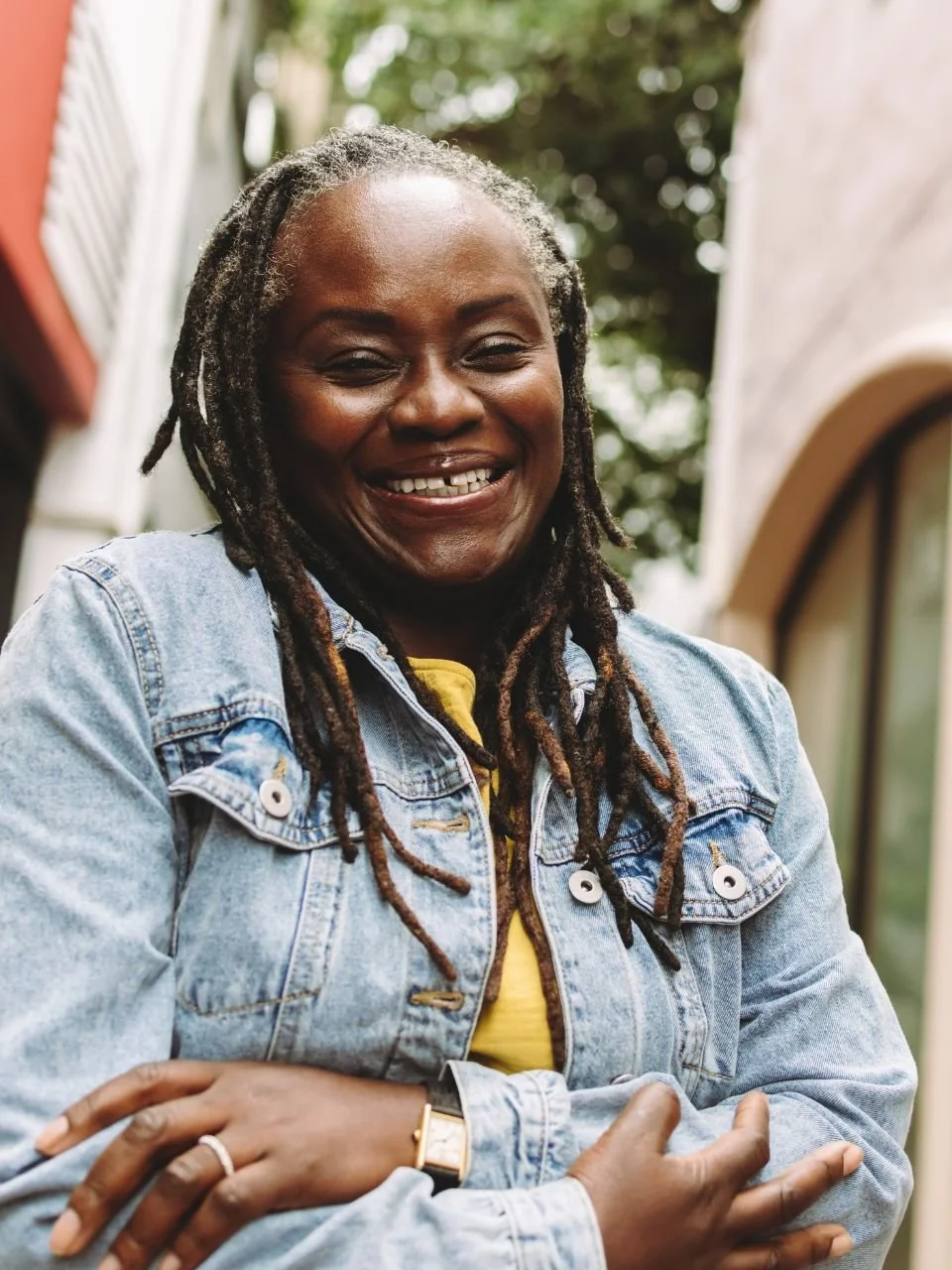 Smiling woman in a denim jacket, representing midlife transitions therapy in Newport, Oregon