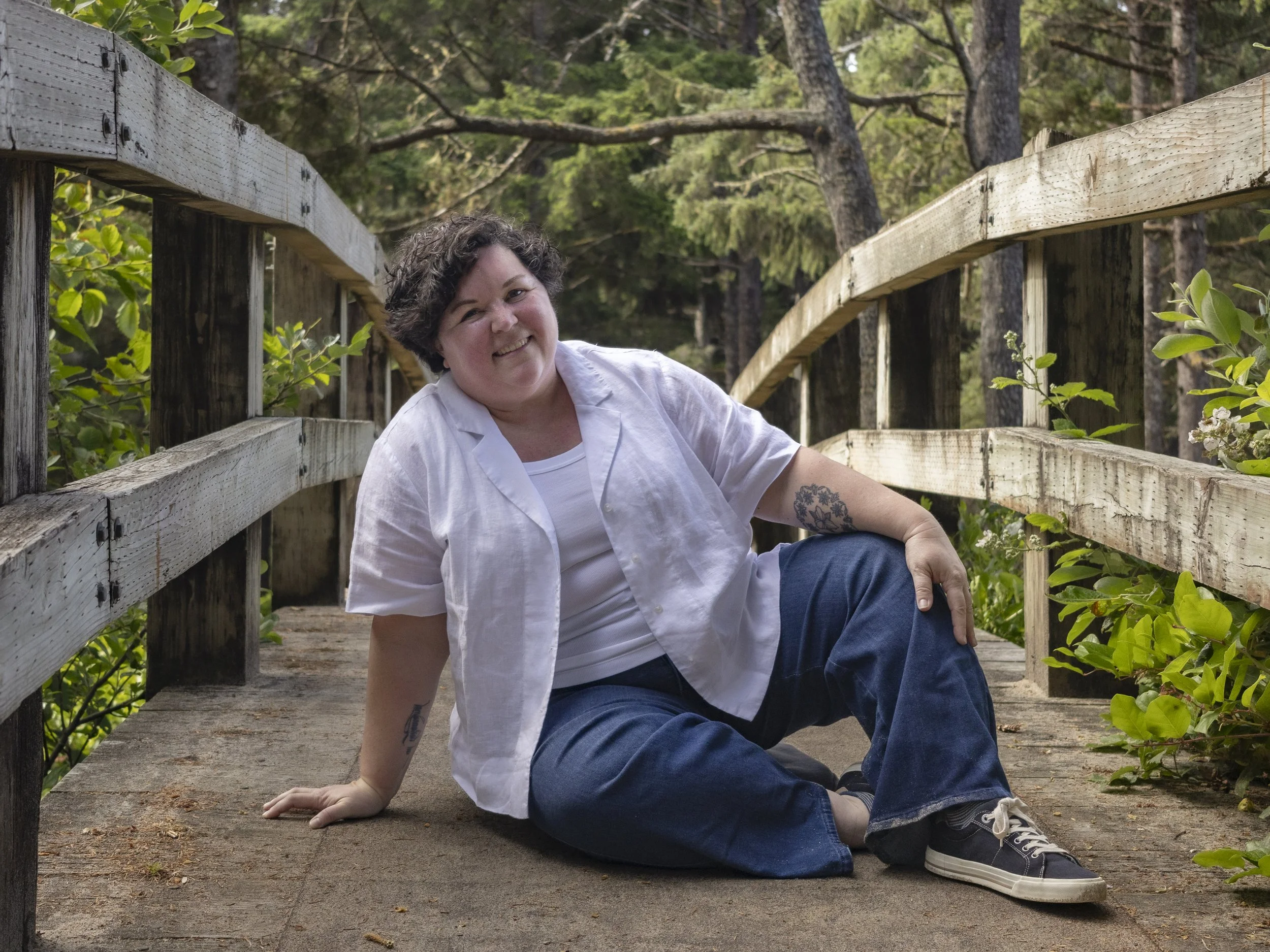 Heather Pierce, LMFT, sitting on a boardwalk bridge, therapist for body image and disordered eating in Newport, Oregon
