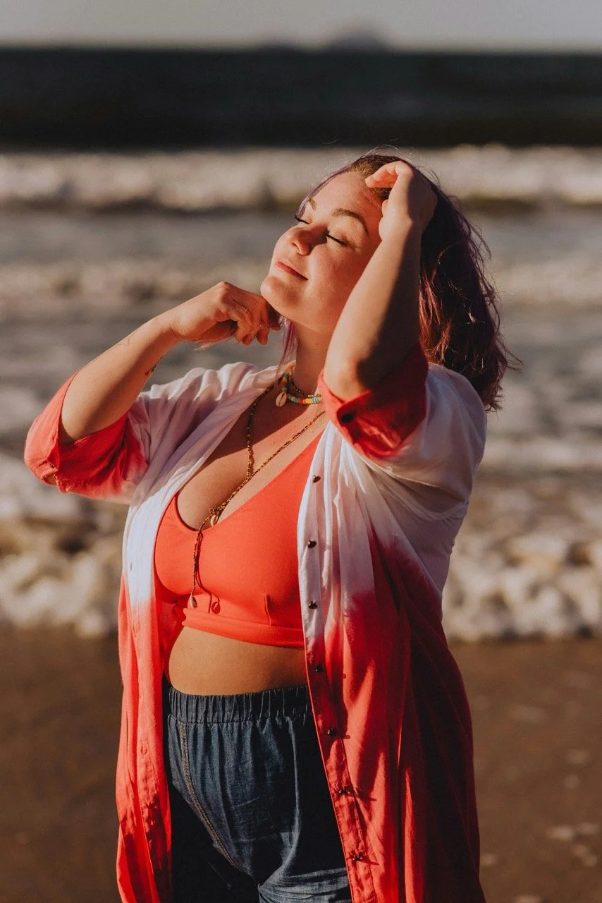 Woman relaxing on the beach with hand in her hair, representing the calm and support found through therapy in Newport, Oregon