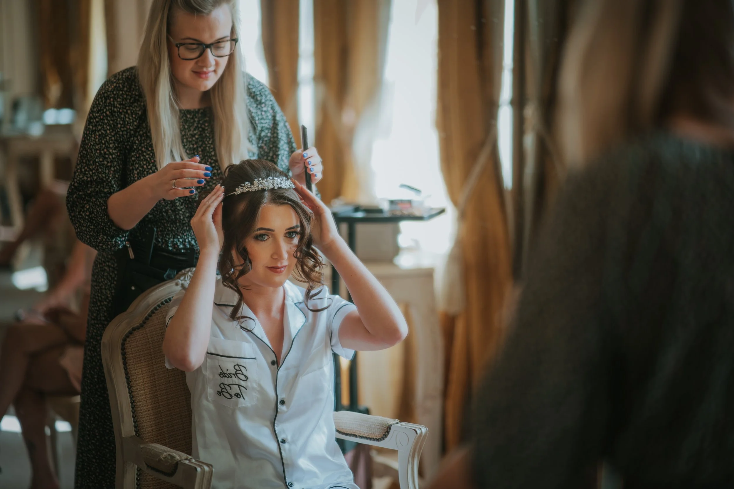 Adding finishing touches to a brides hair at Gosfield Hall Essex
