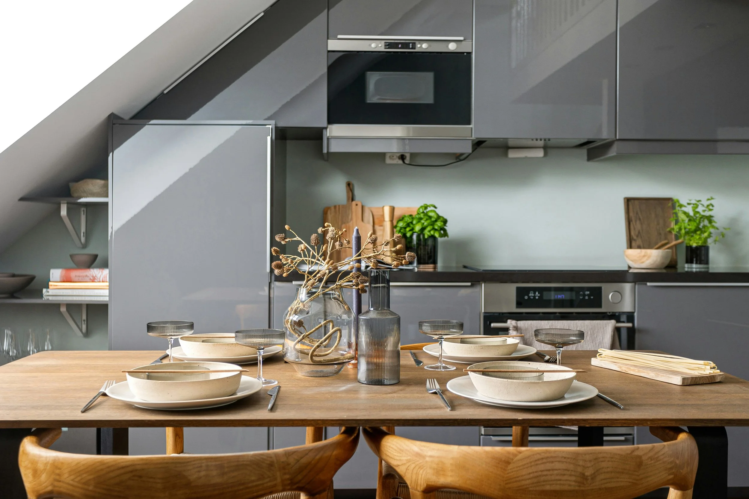 Mountain range with snow-capped peaks, rolling grassy hills in the foreground, and a modern building located on the hillside.