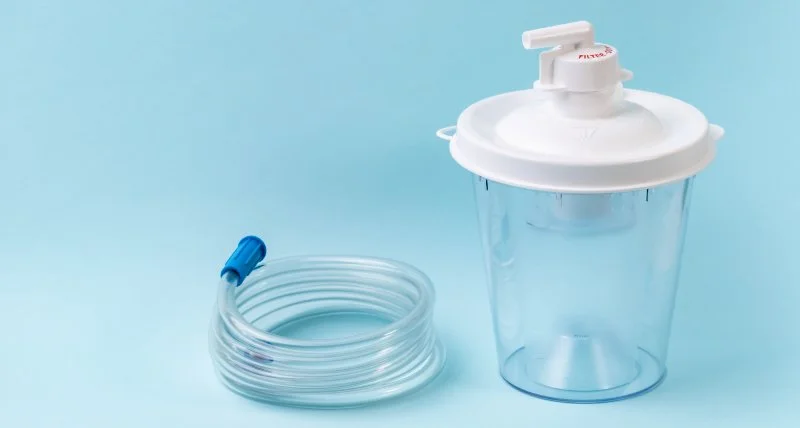 A water filter with a clear plastic container and a coiled tube with a blue end on a light blue background.
