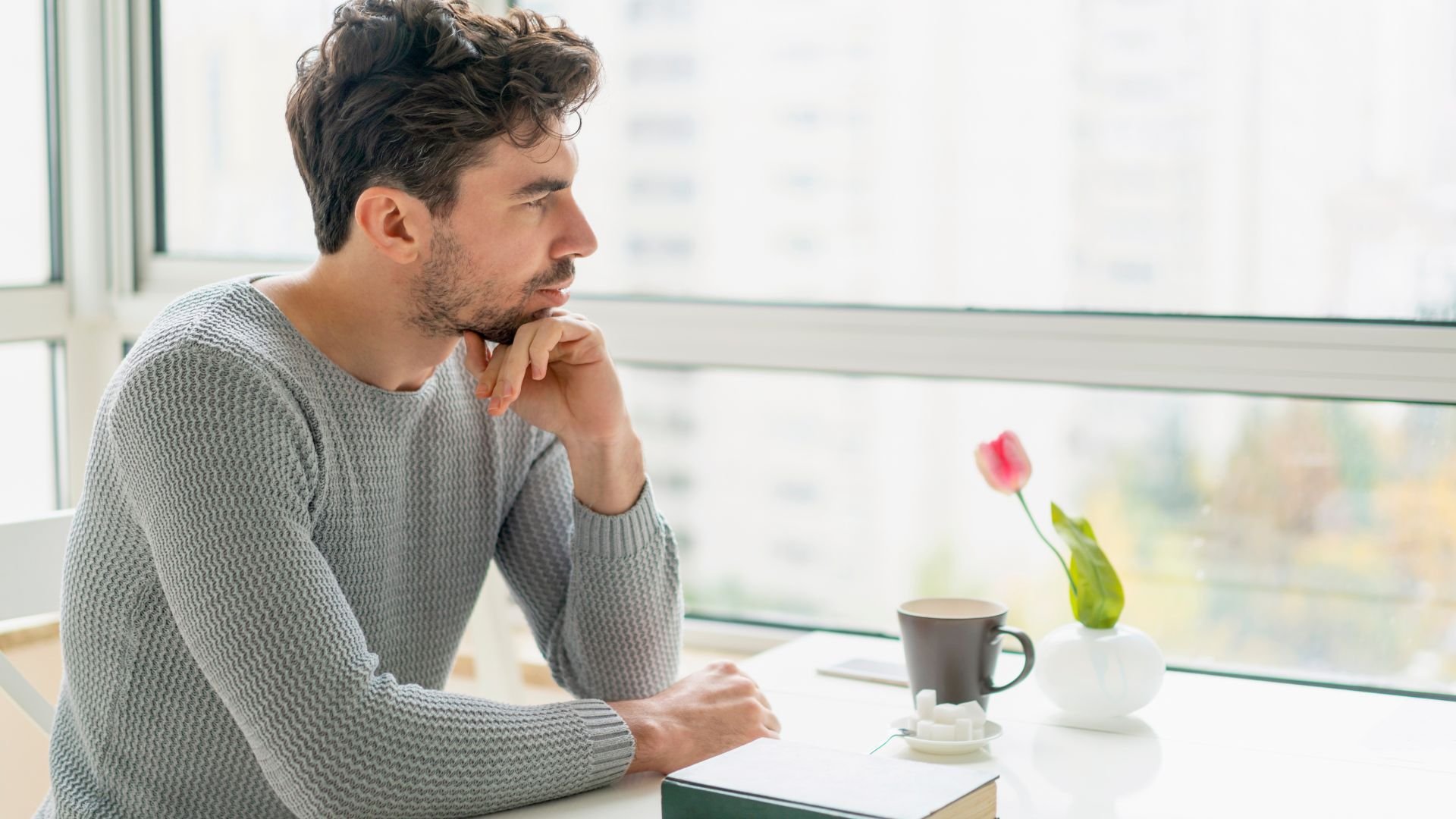 Reflective adult sitting alone, representing the lasting emotional impact of difficult experiences.