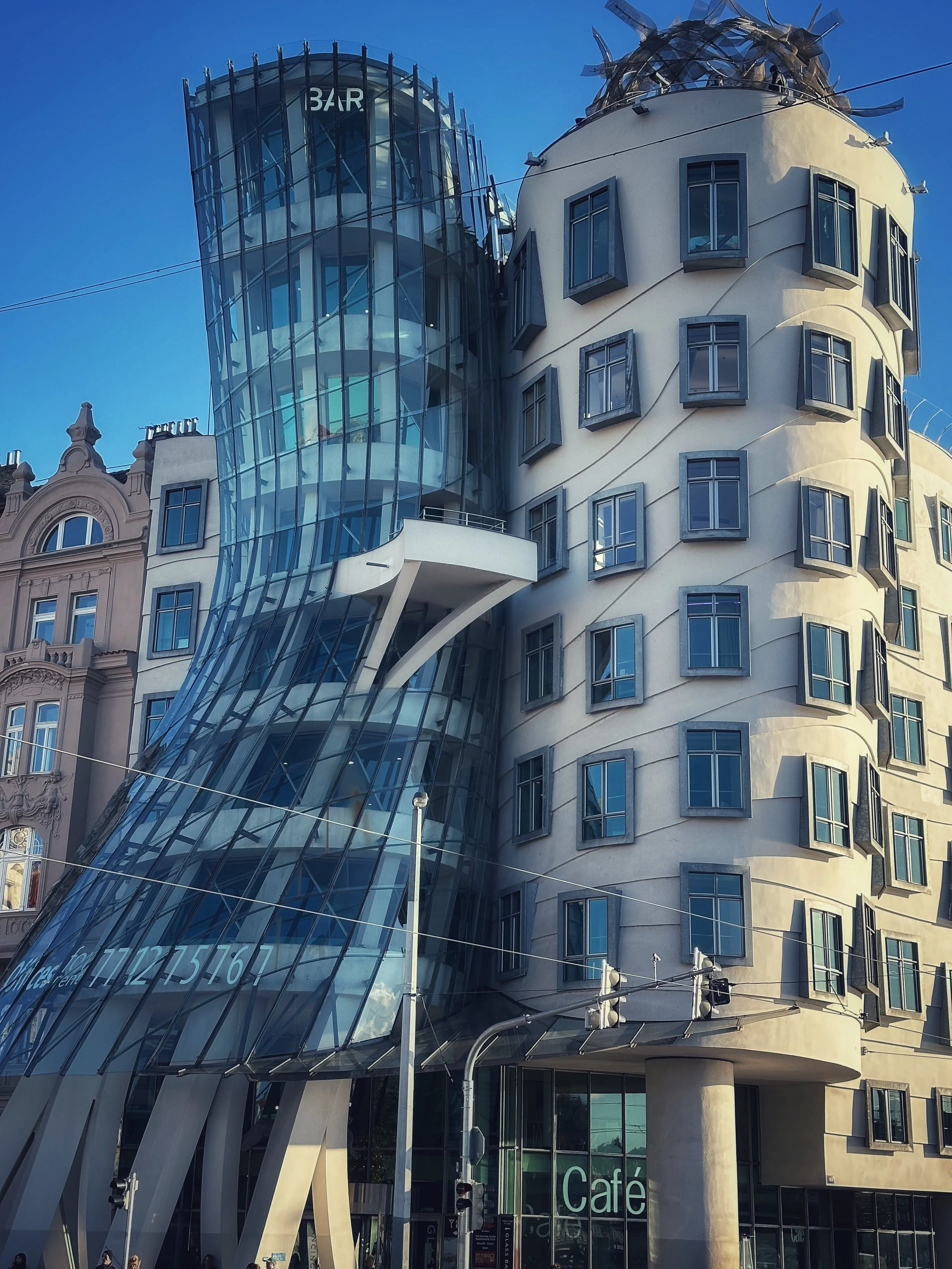 Dancing House in Prague, modern glass and concrete building against a clear blue sky