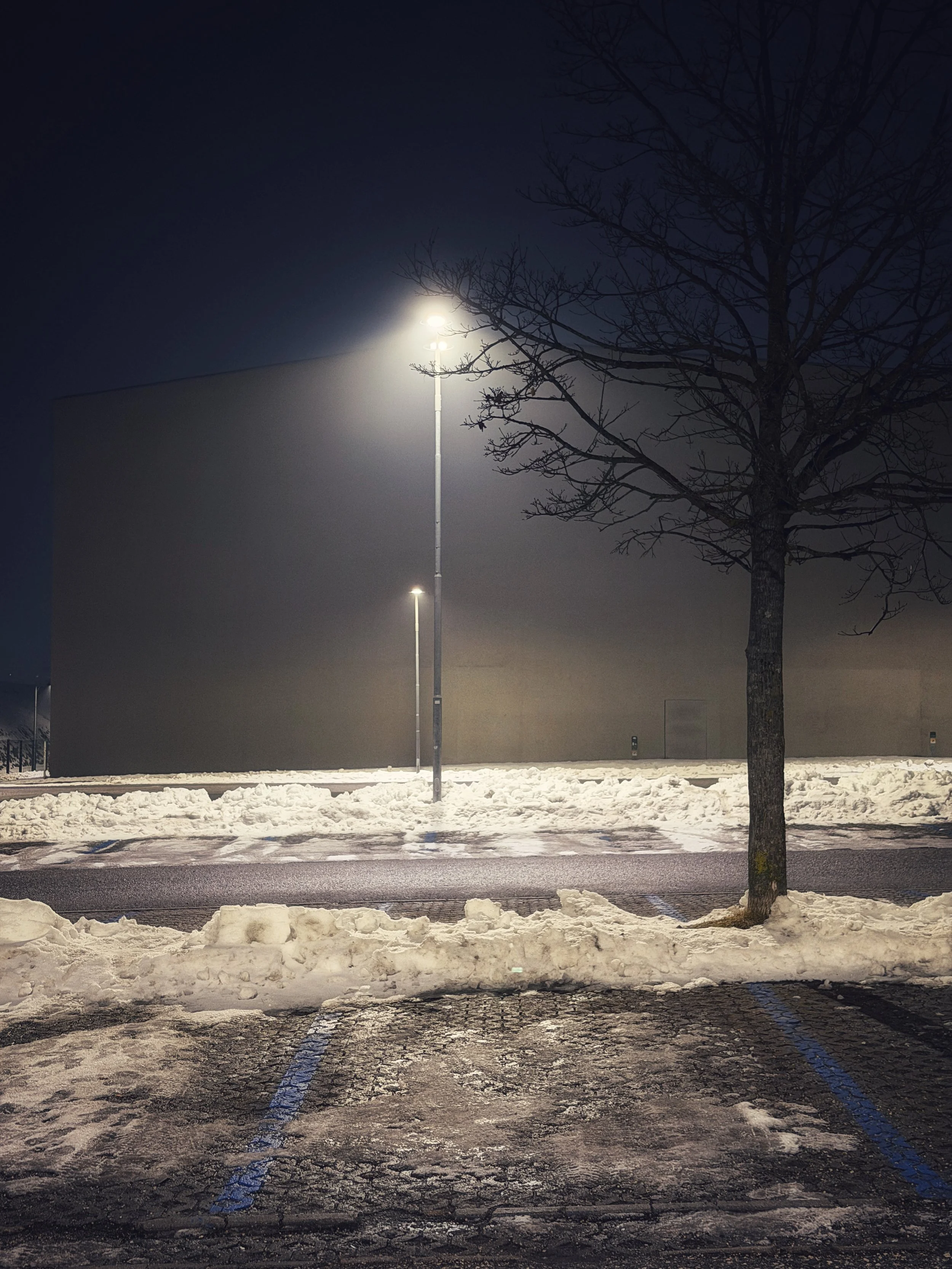 Snow-covered street at night with a single streetlight in winter.
