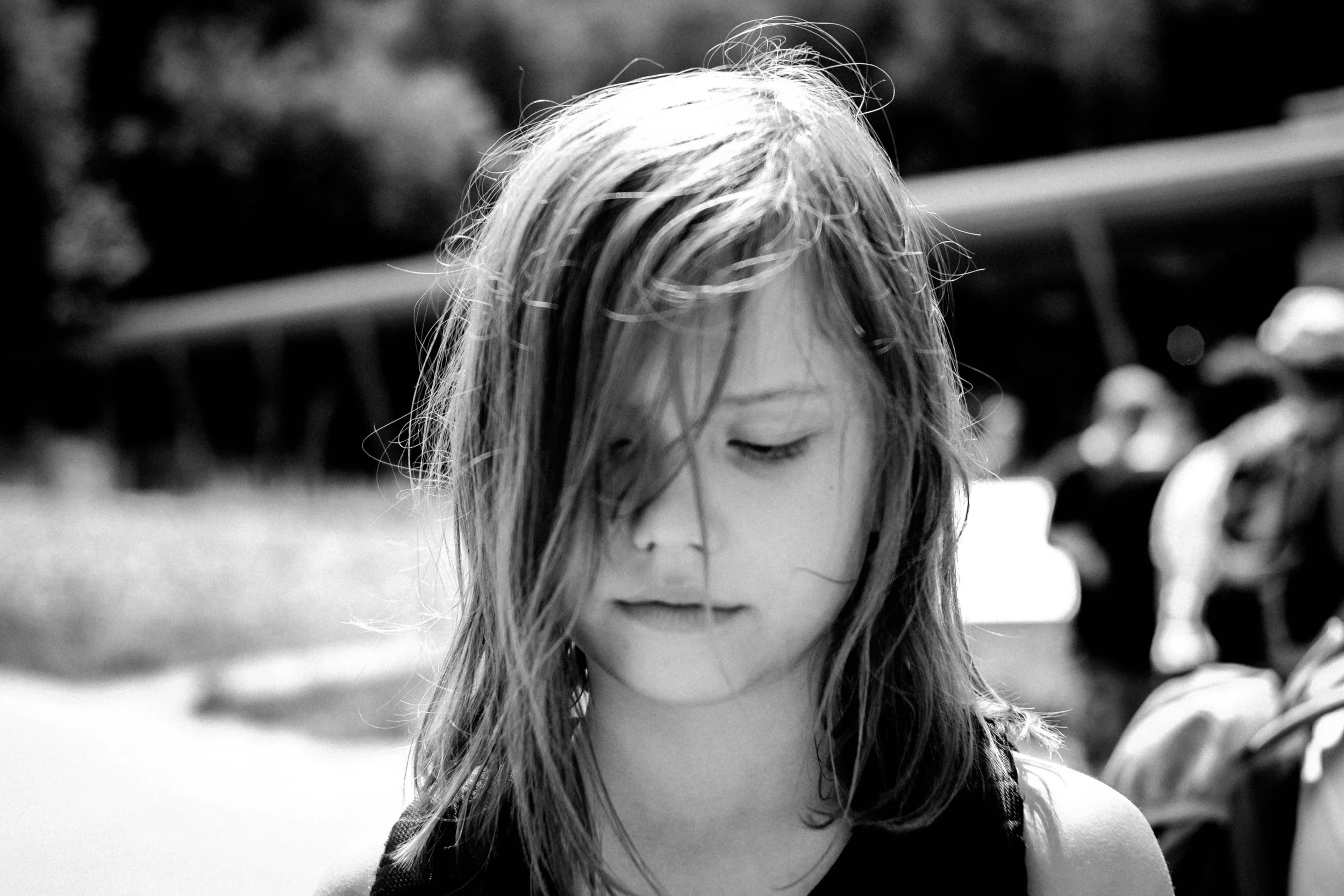 Schwarz-weiß-Foto eines Mädchens mit nassem Haar, das nach unten schaut.