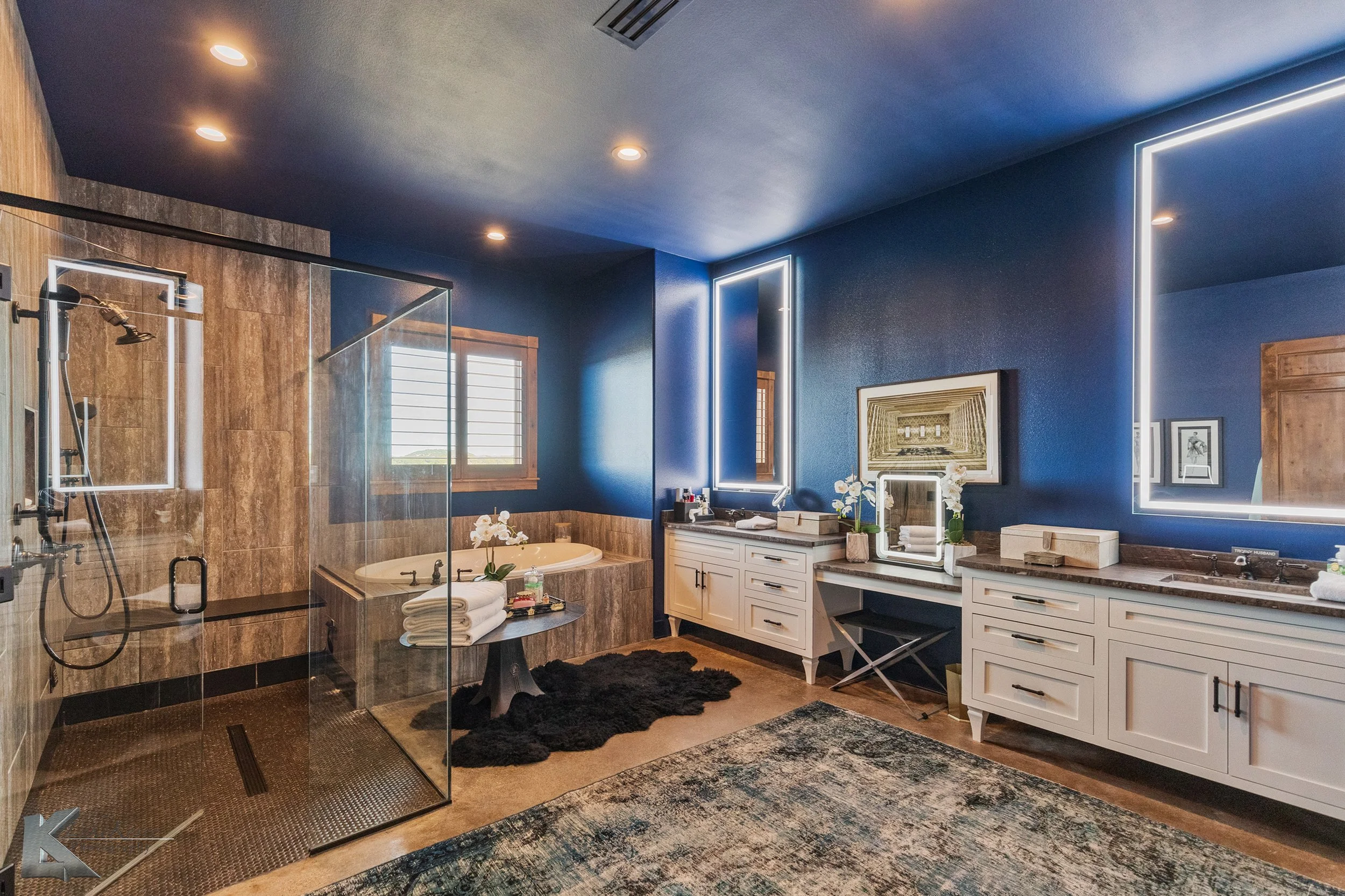 The bath has dual vanities, a tub & separate shower with stone finishes.