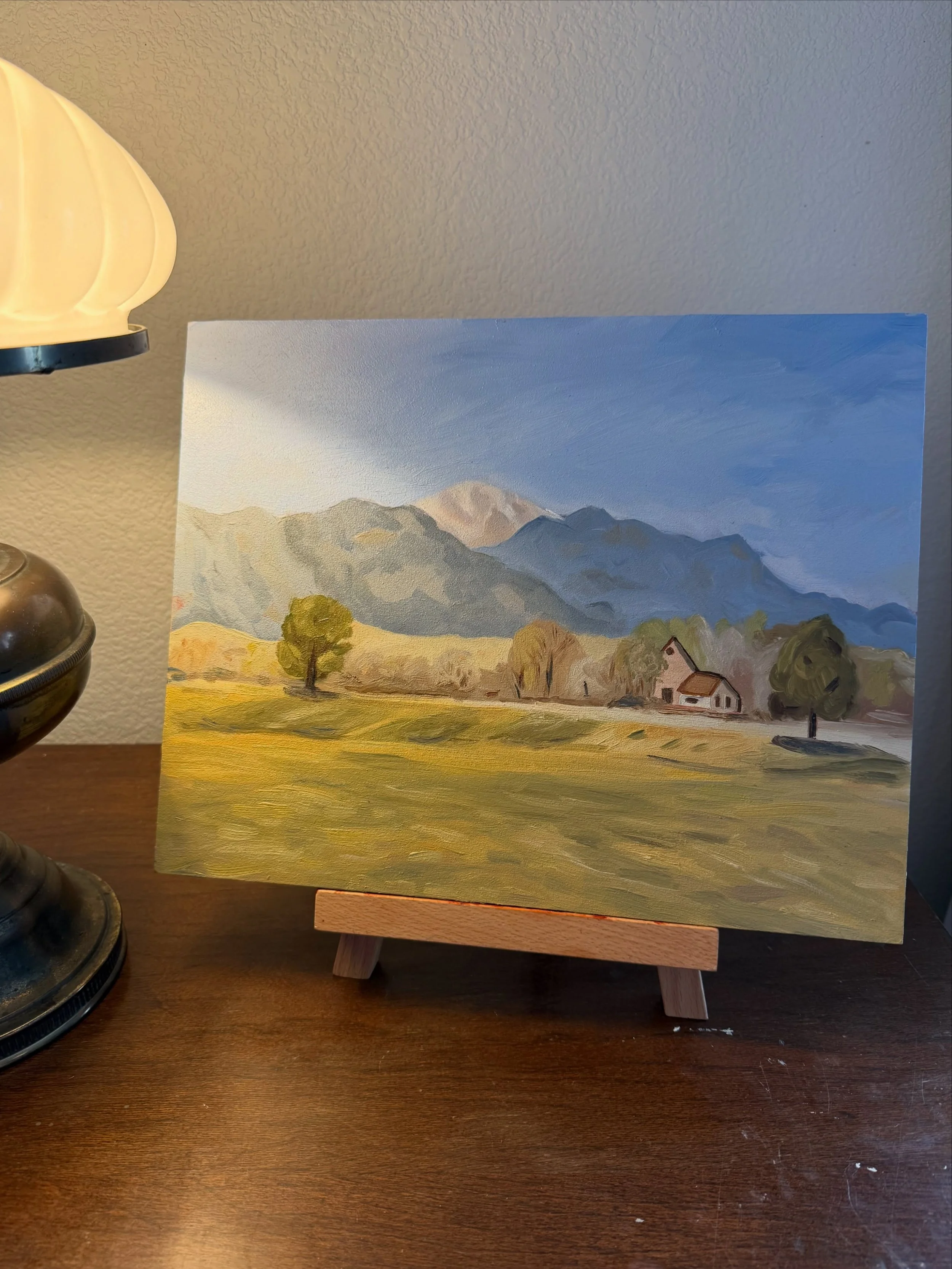 Oil painting of Pikes Peak with snow over a green field at Fountain Creek Park, Colorado.