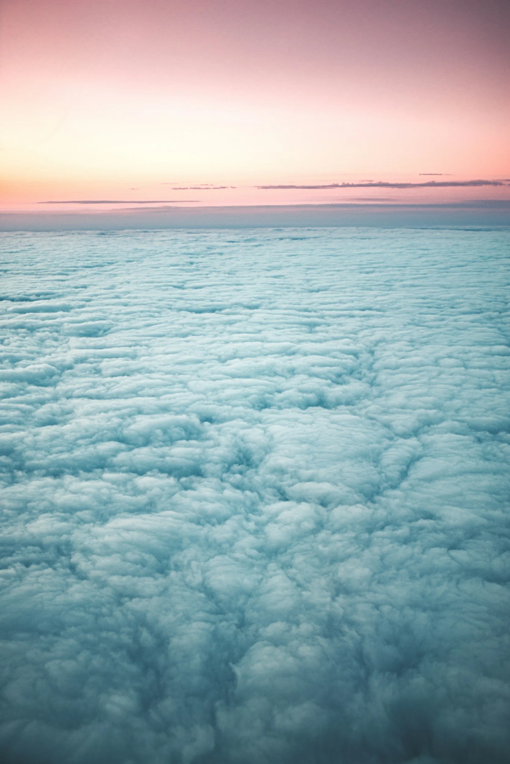 Clouds over the horizon during sunset or sunrise with a colorful sky in pink and orange hues.