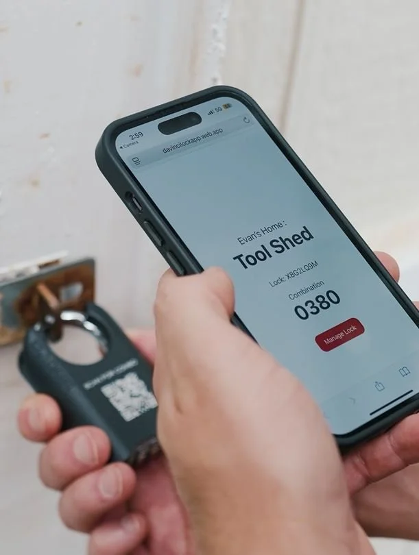 A person holding a smartphone displaying a home automation app for a tool shed, with a lock code, and a key fob in their other hand.