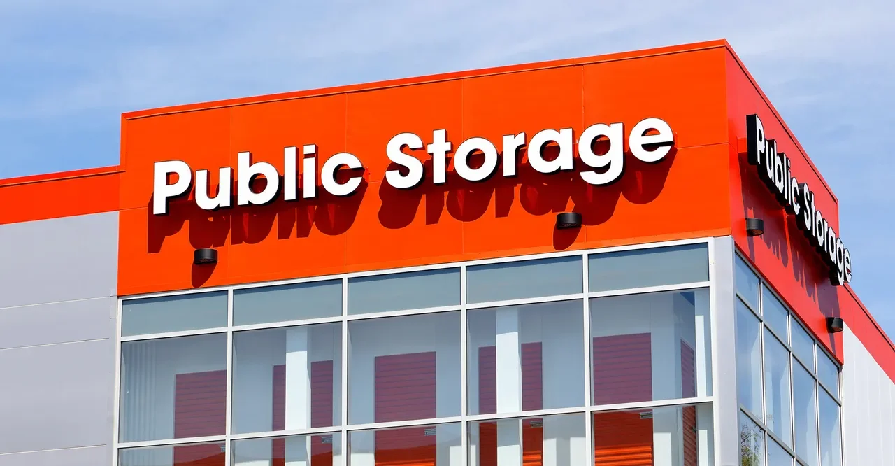 Exterior of a public storage facility with orange and white colors, large sign reading 'Public Storage' on the building.