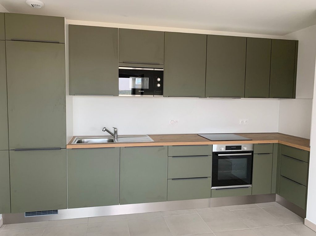 État avant travaux – cuisine appartement neuf témoin à Bordeaux, façades vert kaki et plan de travail bois sans décoration – Projet Bordeaux, Anthony Mambré Design architecte d'intérieur