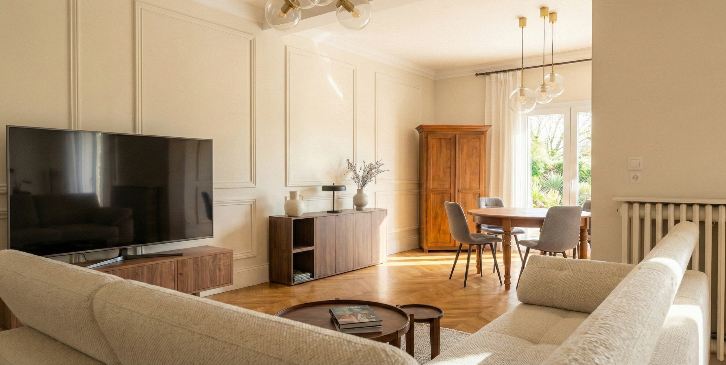 Salon avec boiseries et moulures d'époque rénovées, meuble TV noyer sur mesure, parquet chevrons chêne et vue sur salle à manger – rénovation maison ancienne haut de gamme, architecte d'intérieur Anthony Mambré Design