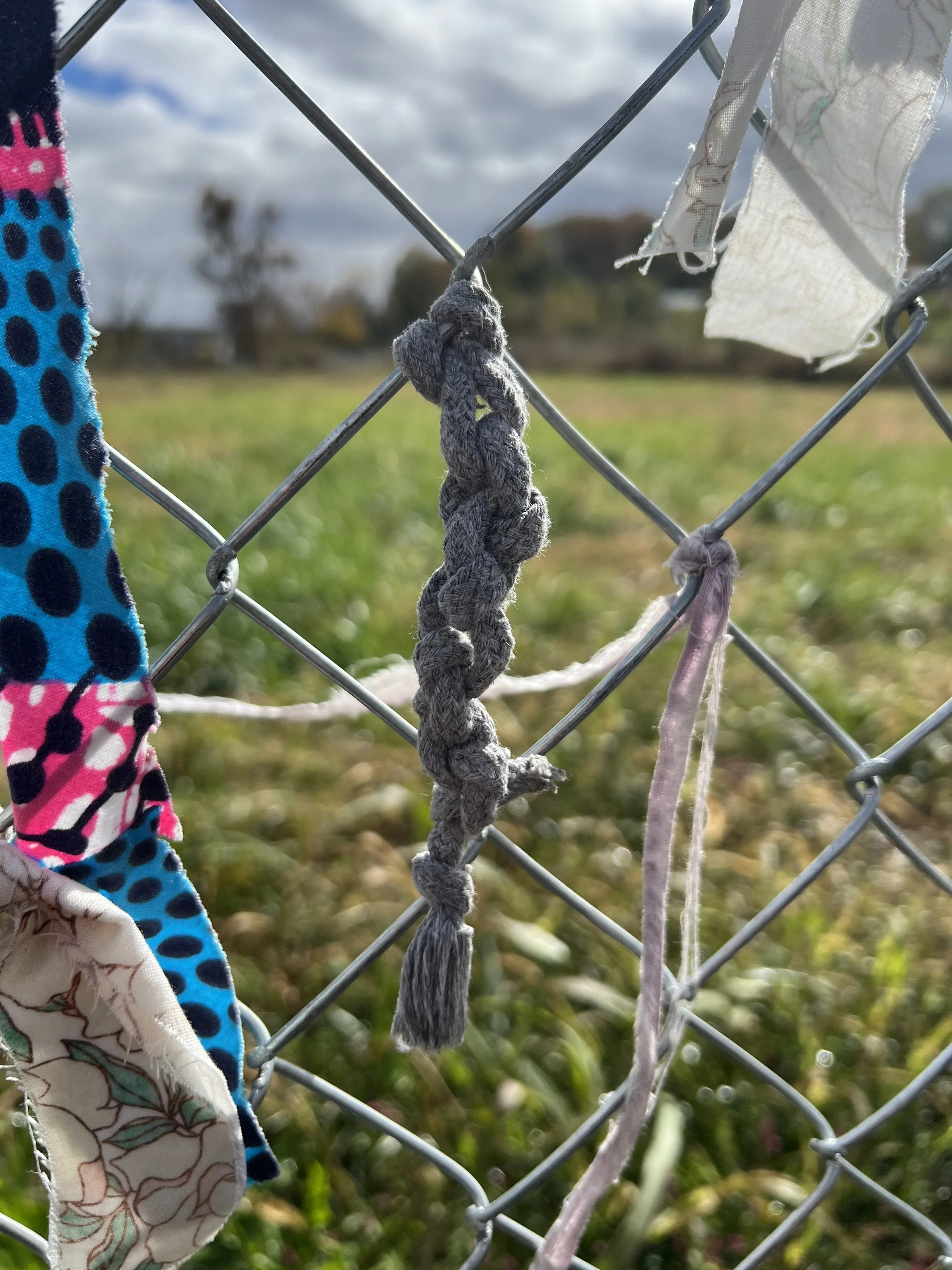 Drawstring-type material knotted in place on the fence.