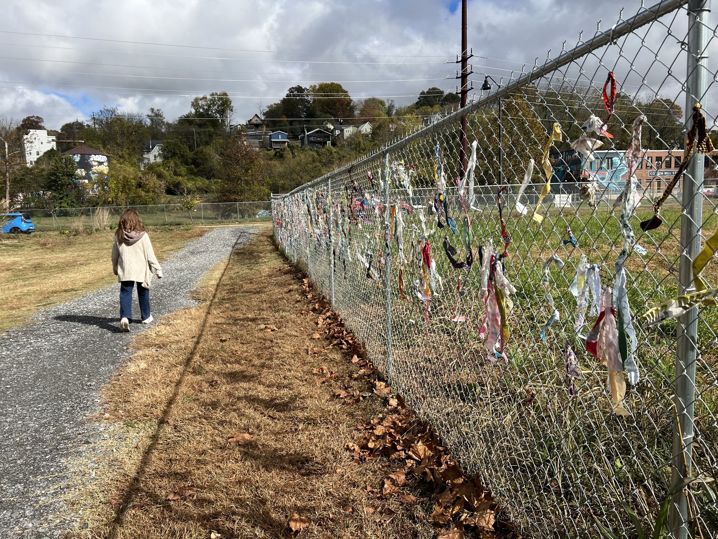 Windblown leaves gather along the corridor as pedestrians continue passing by.