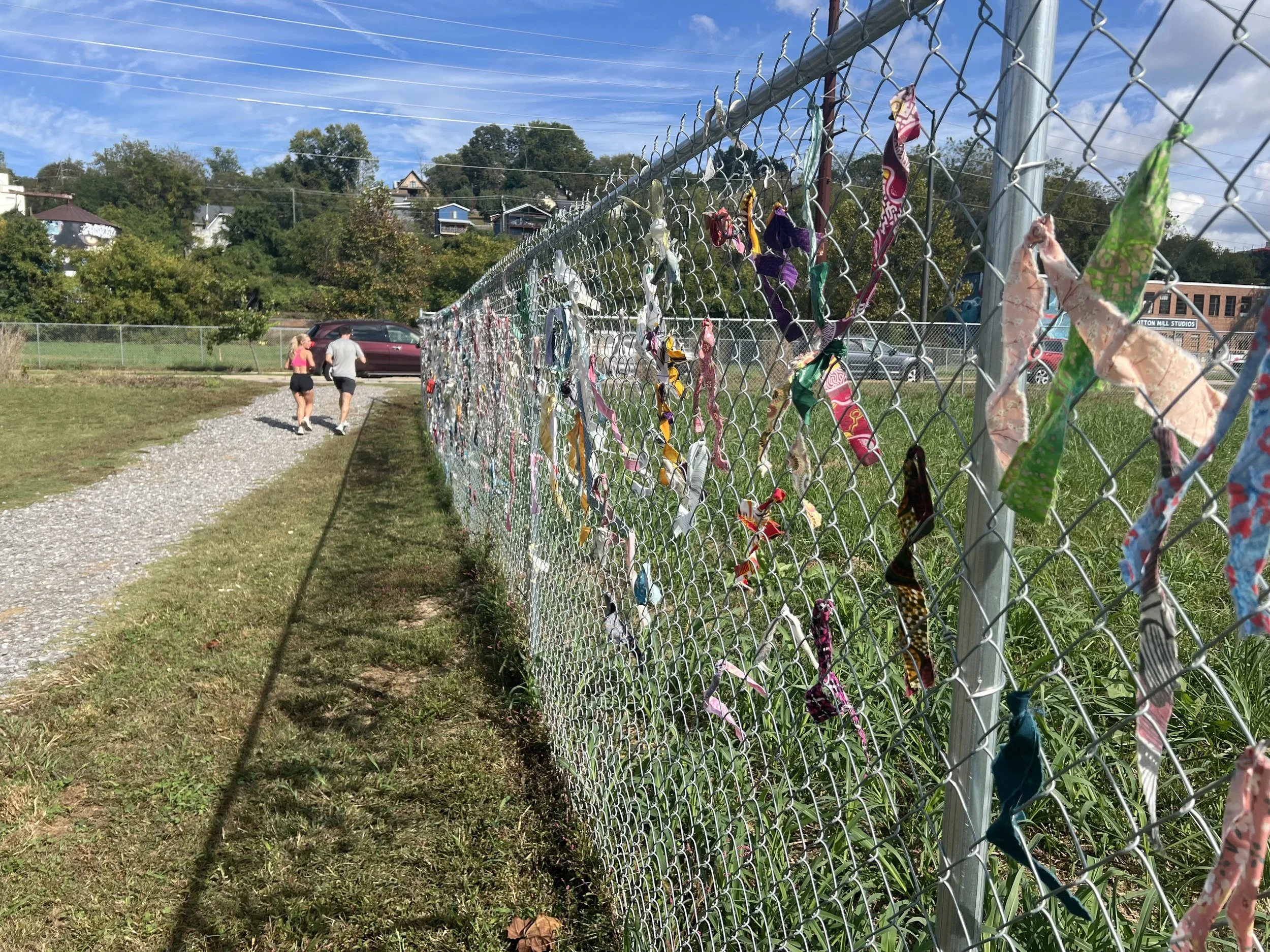Joggers moving through the shared public corridor beside the installation.