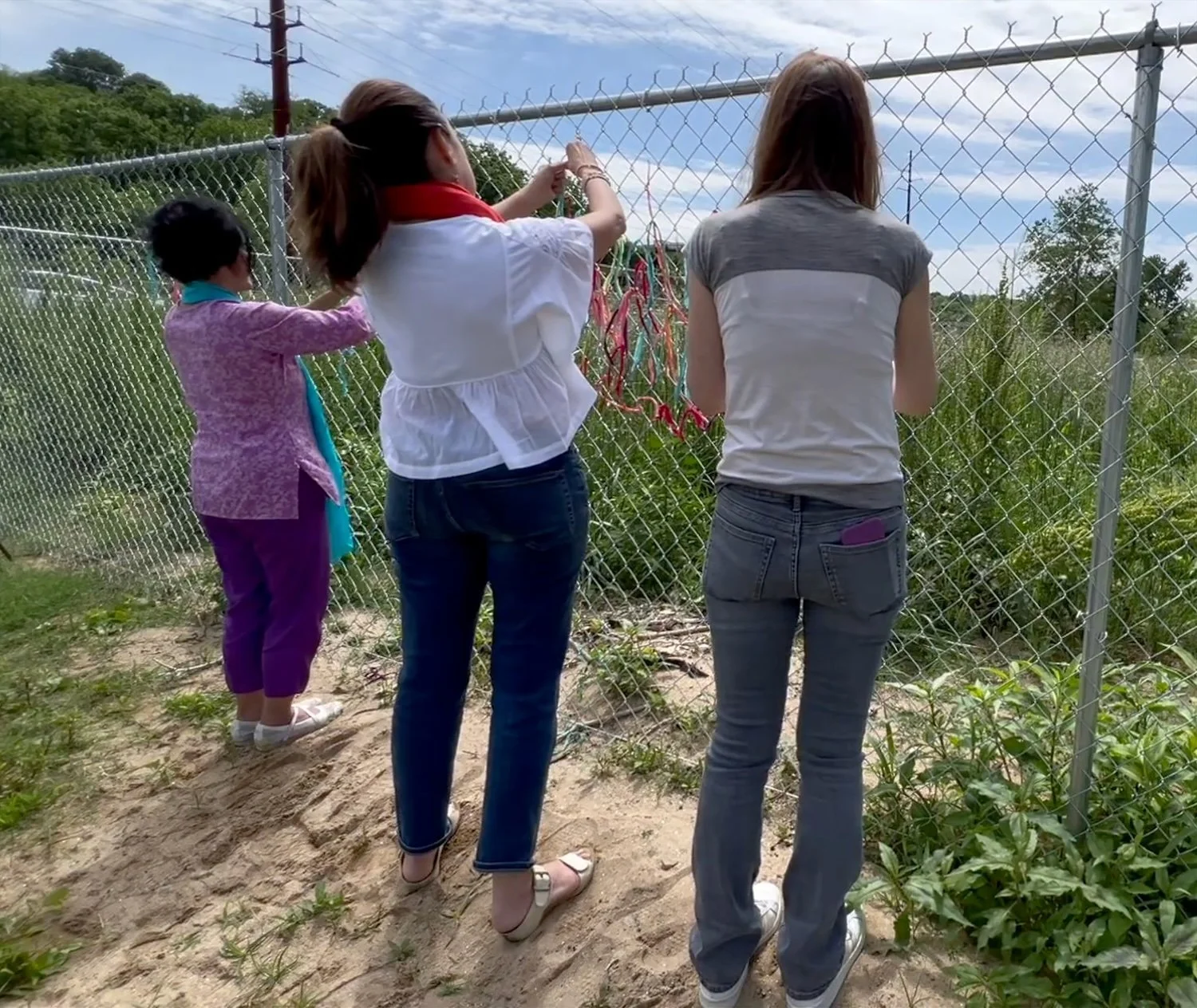Wishes and worries made visible in fabric, lovingly tied to the fence.