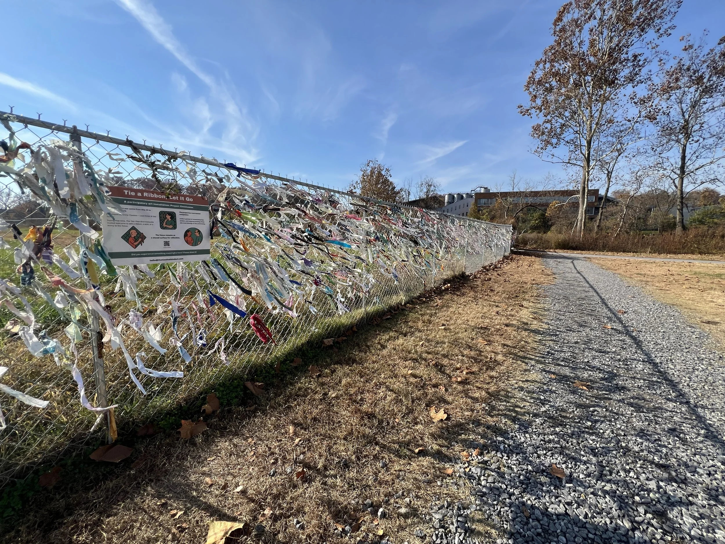 Final day view of The Ties That Bind Asheville installation showing dense fabric strips and closing sign at 172 Riverside Drive in Asheville, North Carolina.