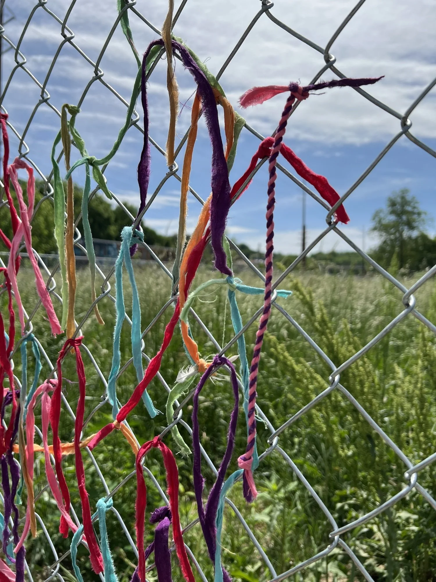 Detail view of the first batch of fabric strips placed on the fence.