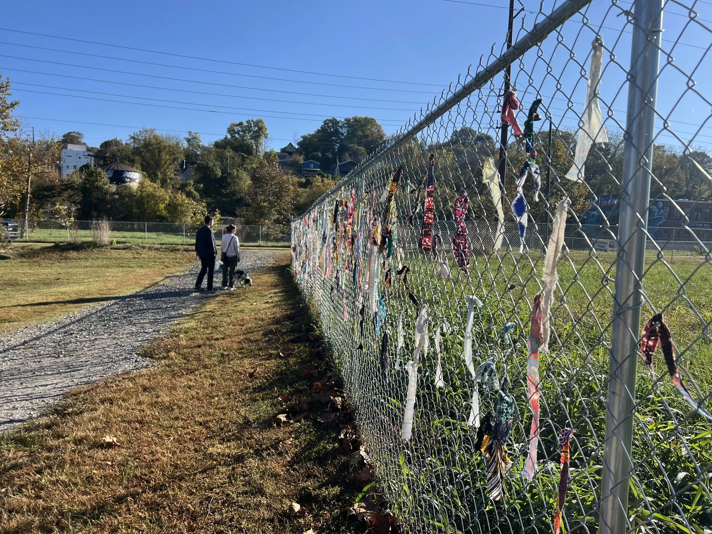 Dog walkers pause beside the participation station during a maintenance visit.