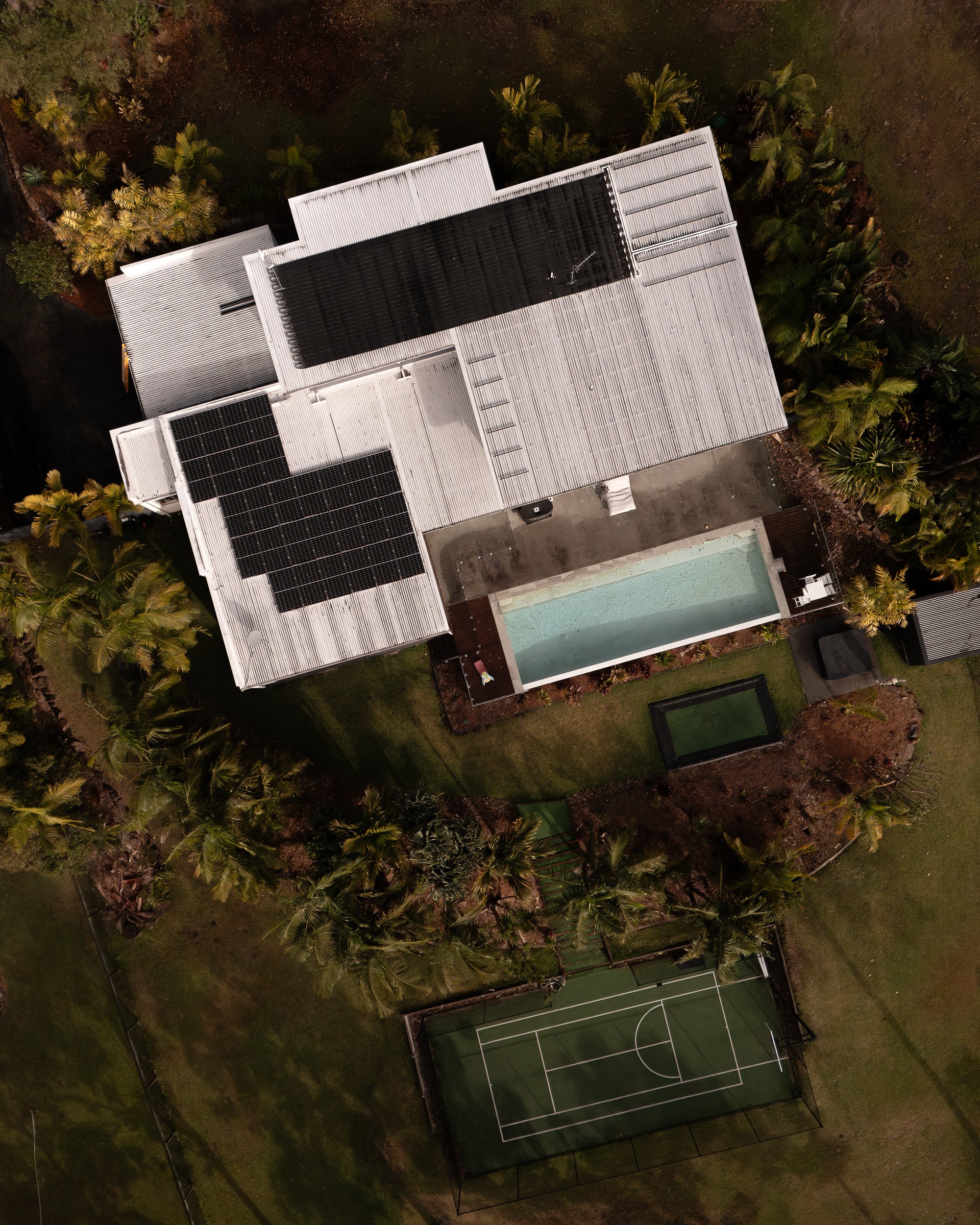 drone shot of home, tennis court and solar