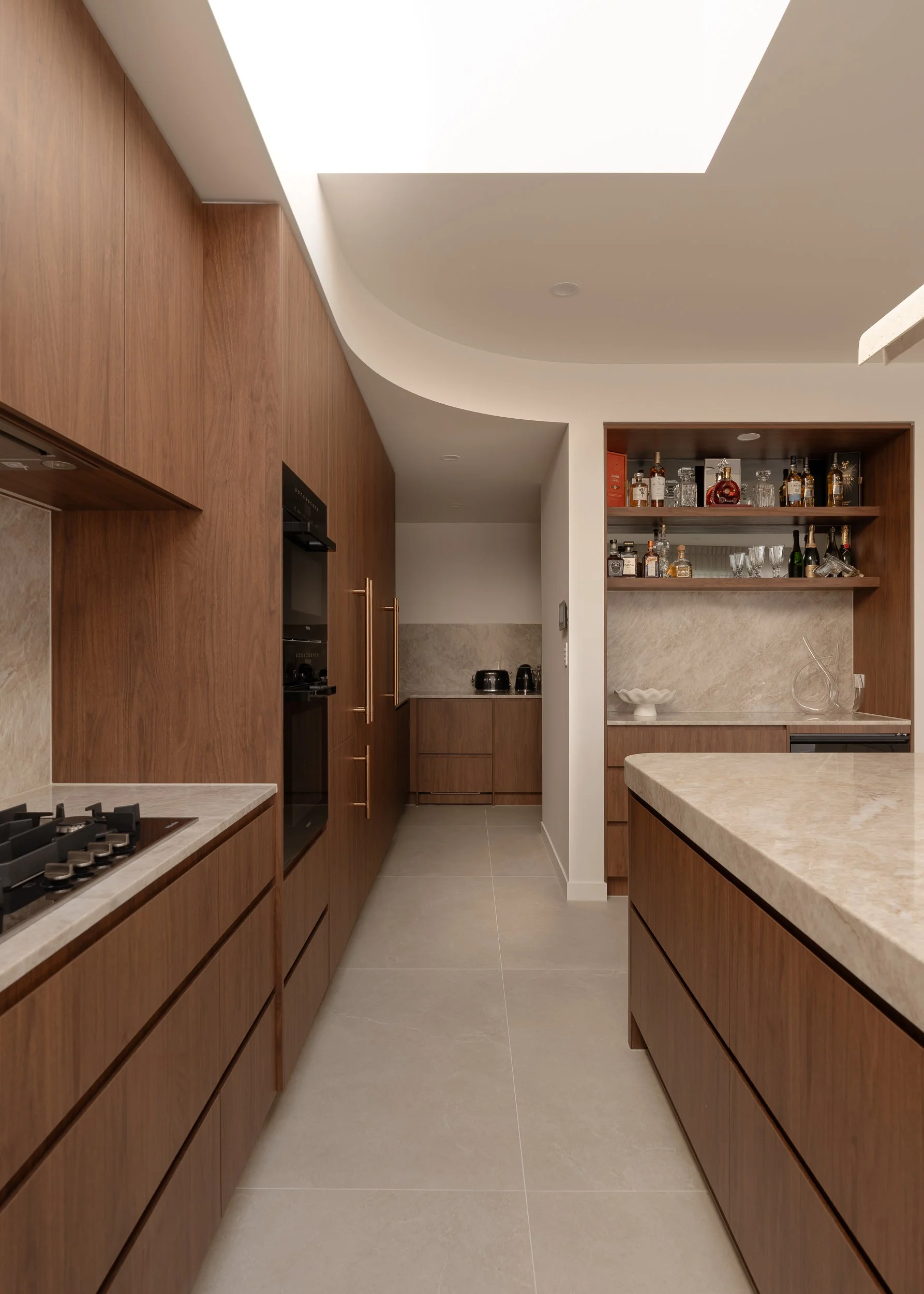 kitchen onto butlers, featuring florentine walnut and natural stone